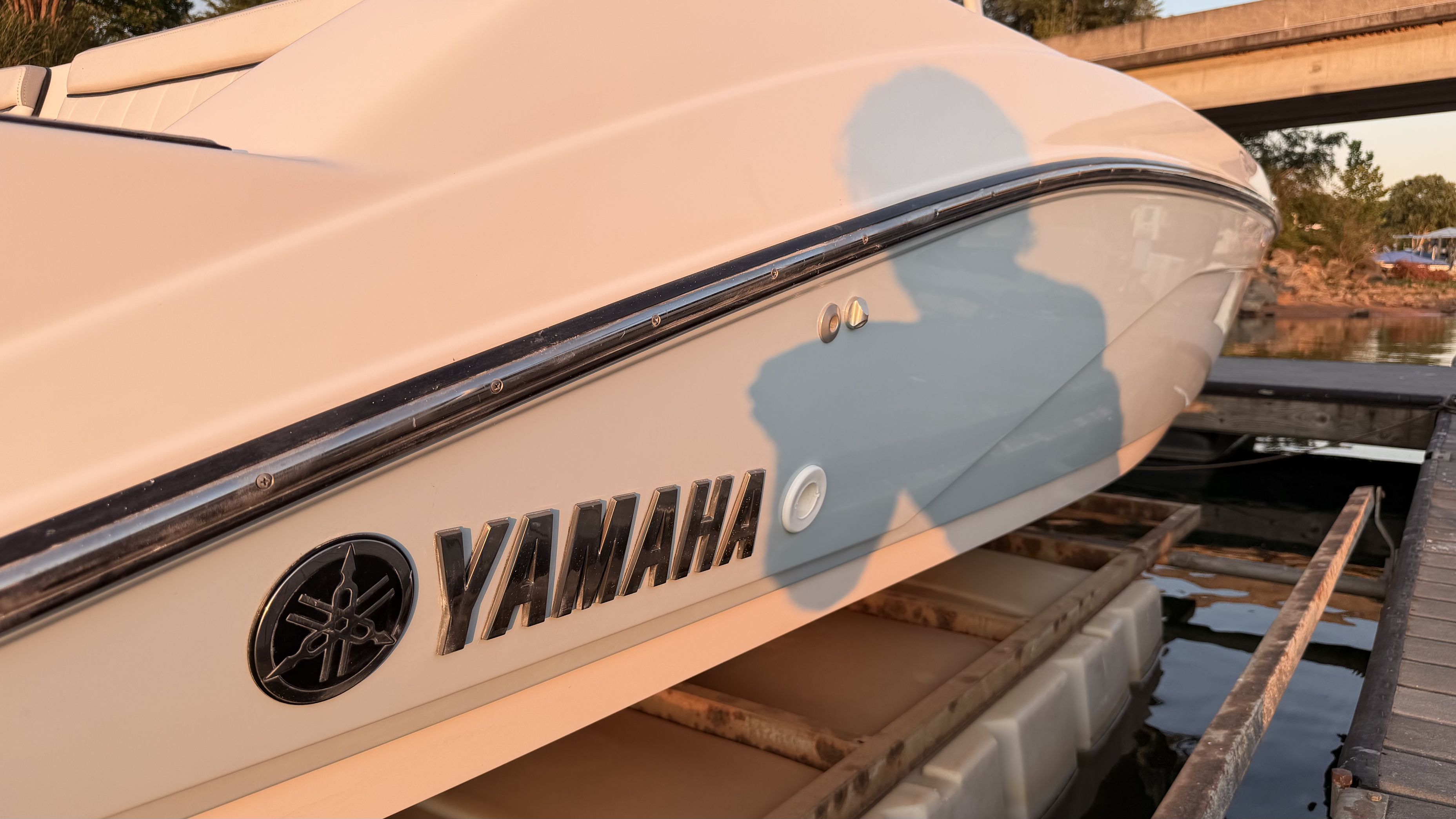 Close-up of a Yamaha boat by the water, with a shadow cast on it.