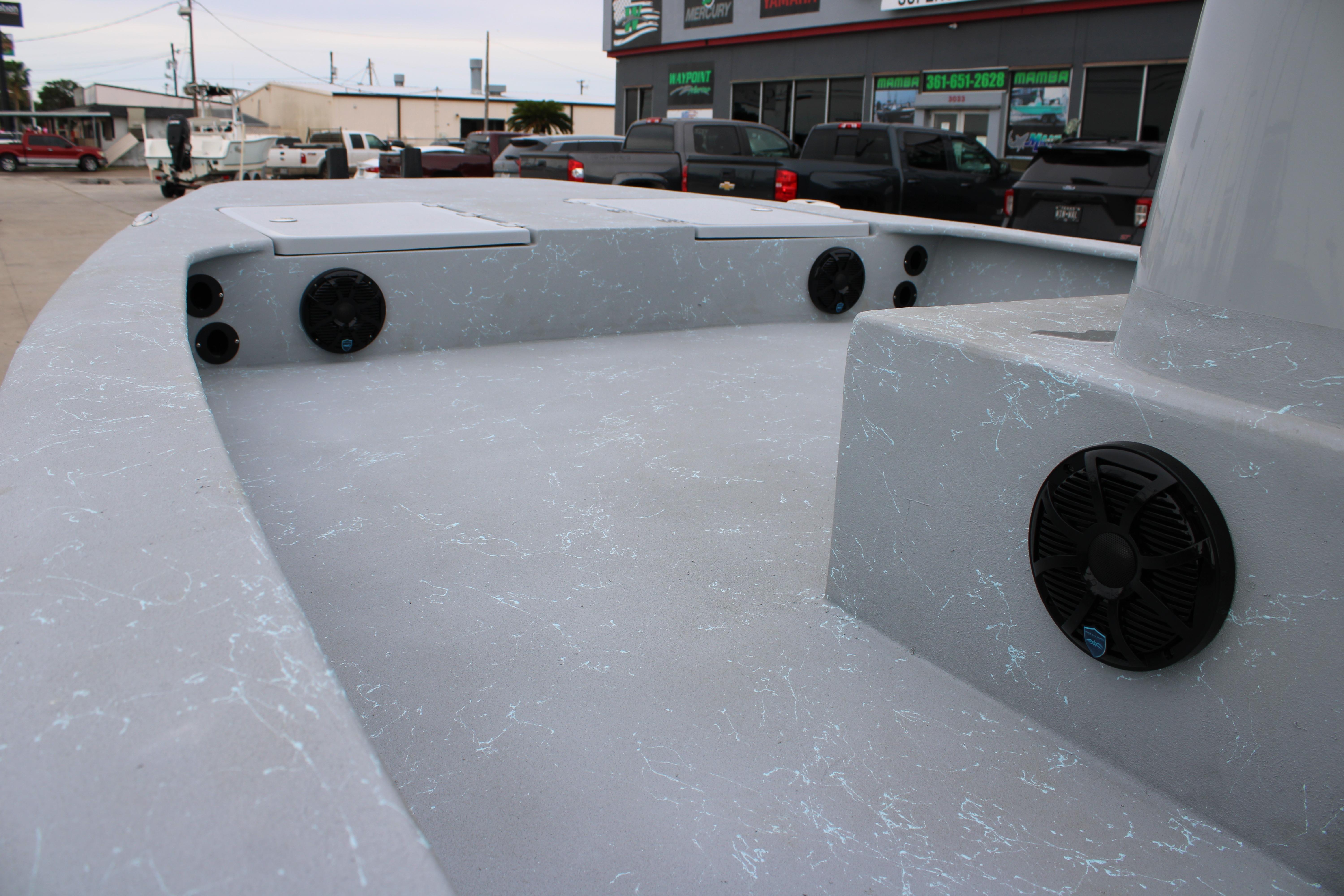 2026 Freedom Boats 24 Defender deck with speakers, parked in a dealership lot.