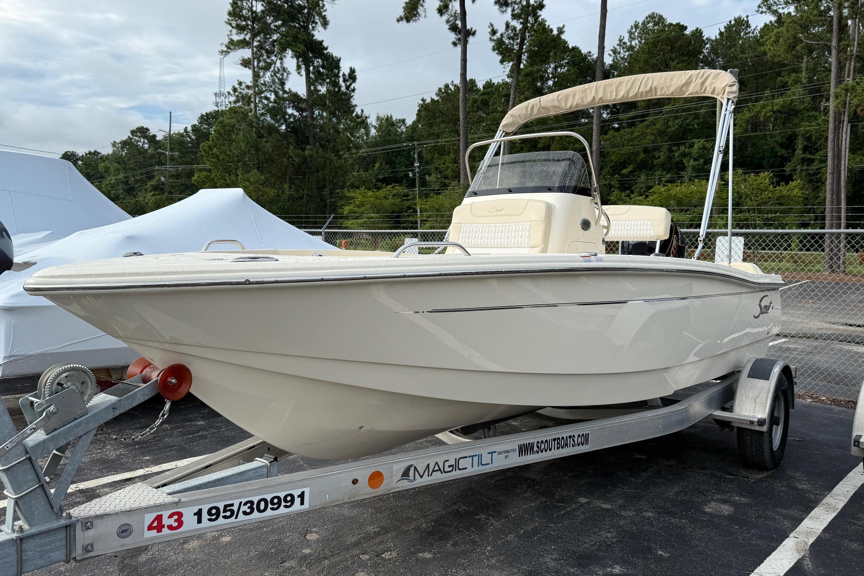 2026 Scout 188 Sportfish boat on trailer, parked outdoors with trees in background.