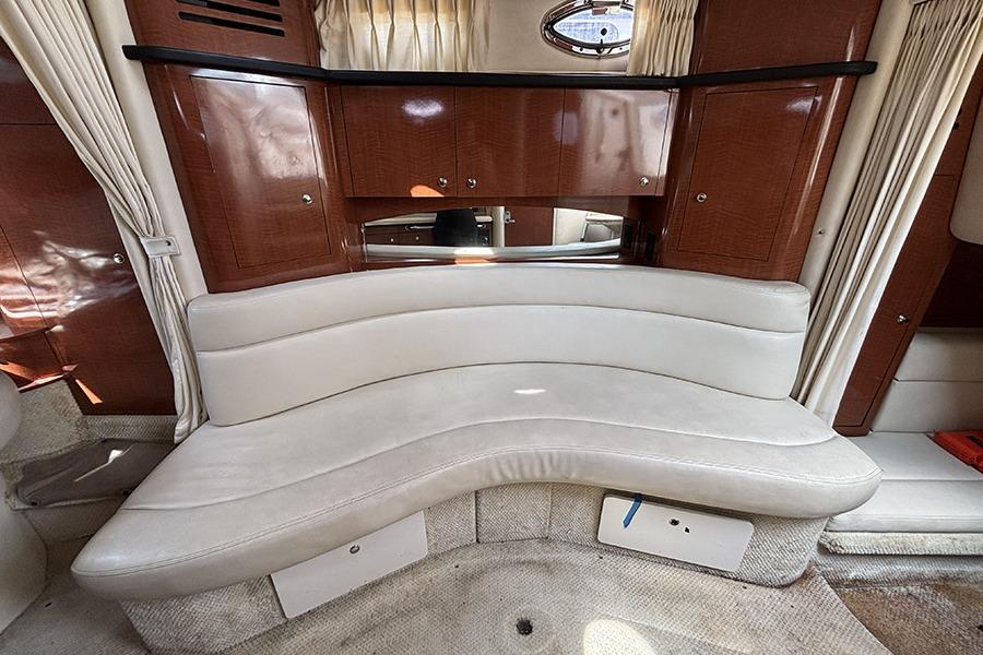 Interior of 2002 Sea Ray Sundancer 320 with curved seating and wooden cabinetry.