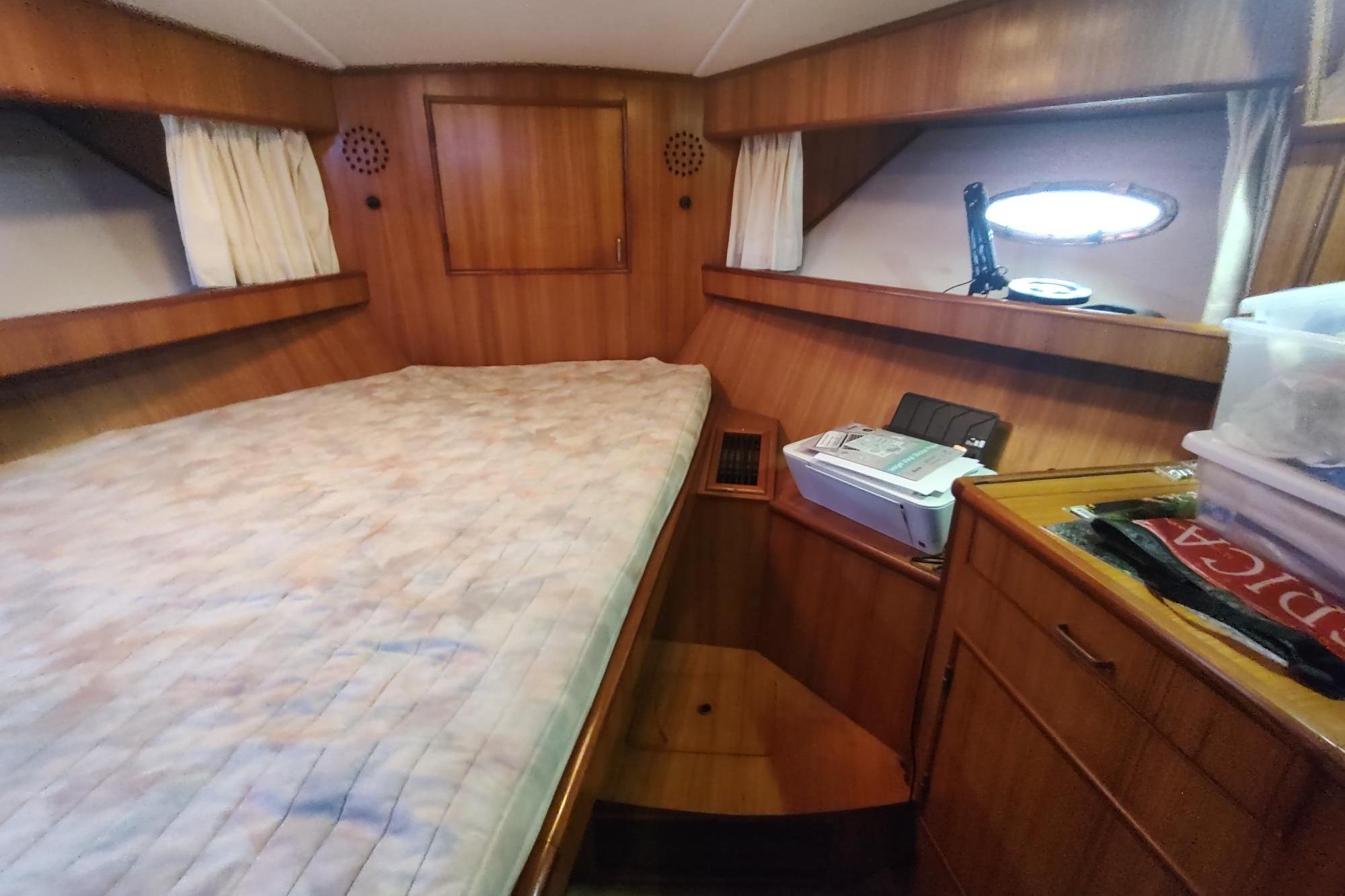 1989 Hyatt Double Cabin Motoryacht interior with wooden paneling and cozy sleeping area.