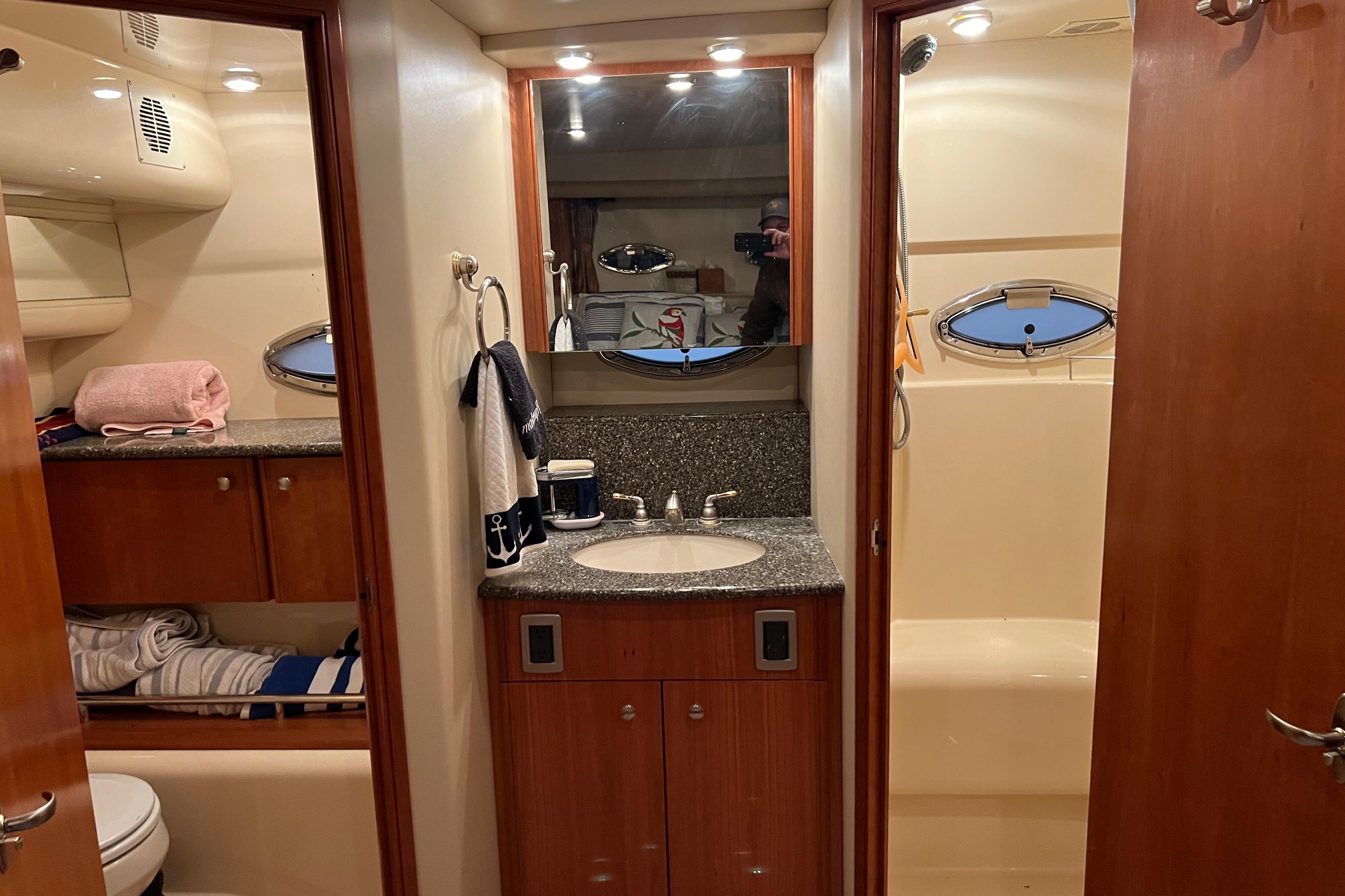 2004 Meridian 408 Motoryacht bathroom with sink, mirror, and shower area.