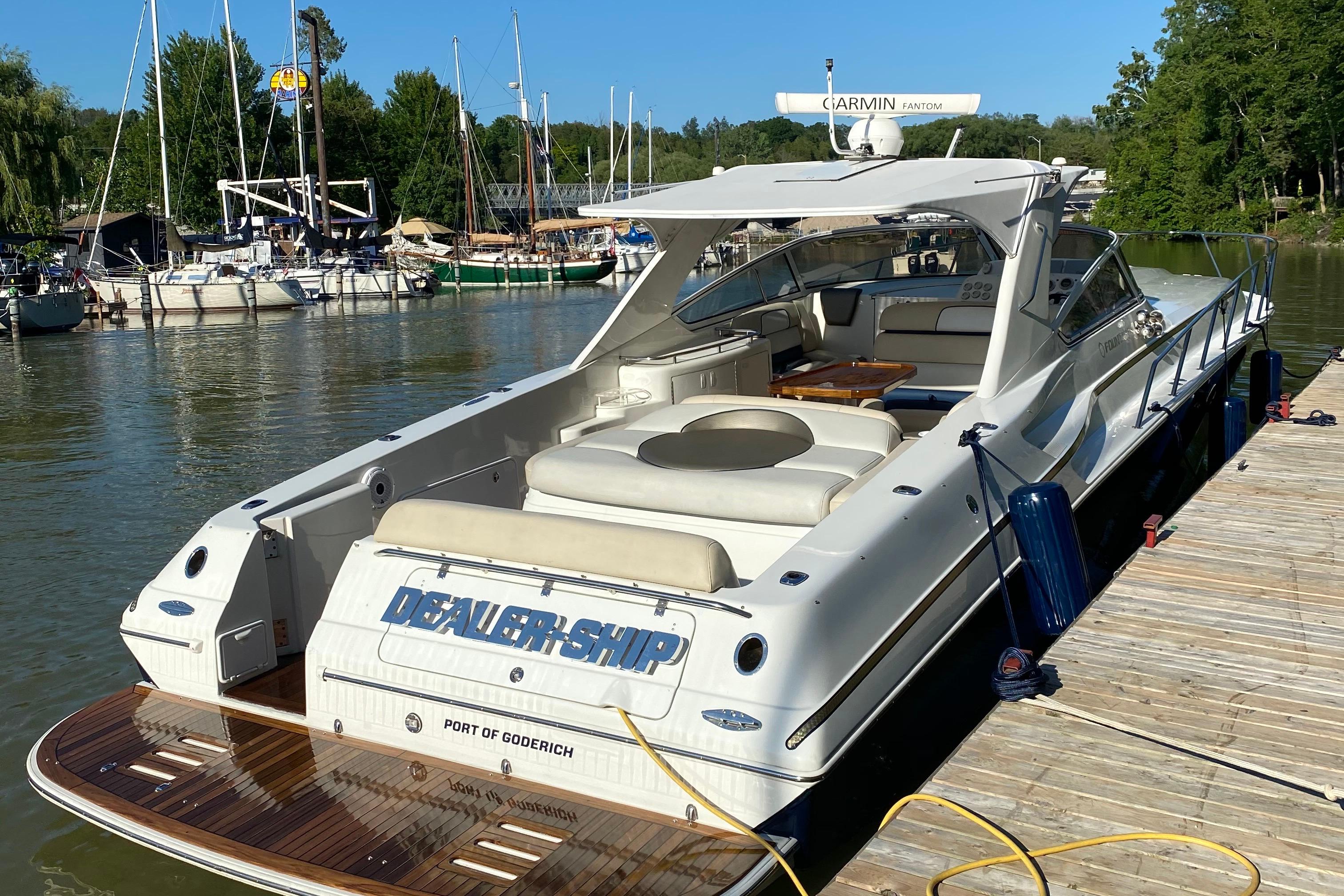 2004 Fountain 48 Express Cruiser docked at a marina, featuring sleek design and spacious seating.
