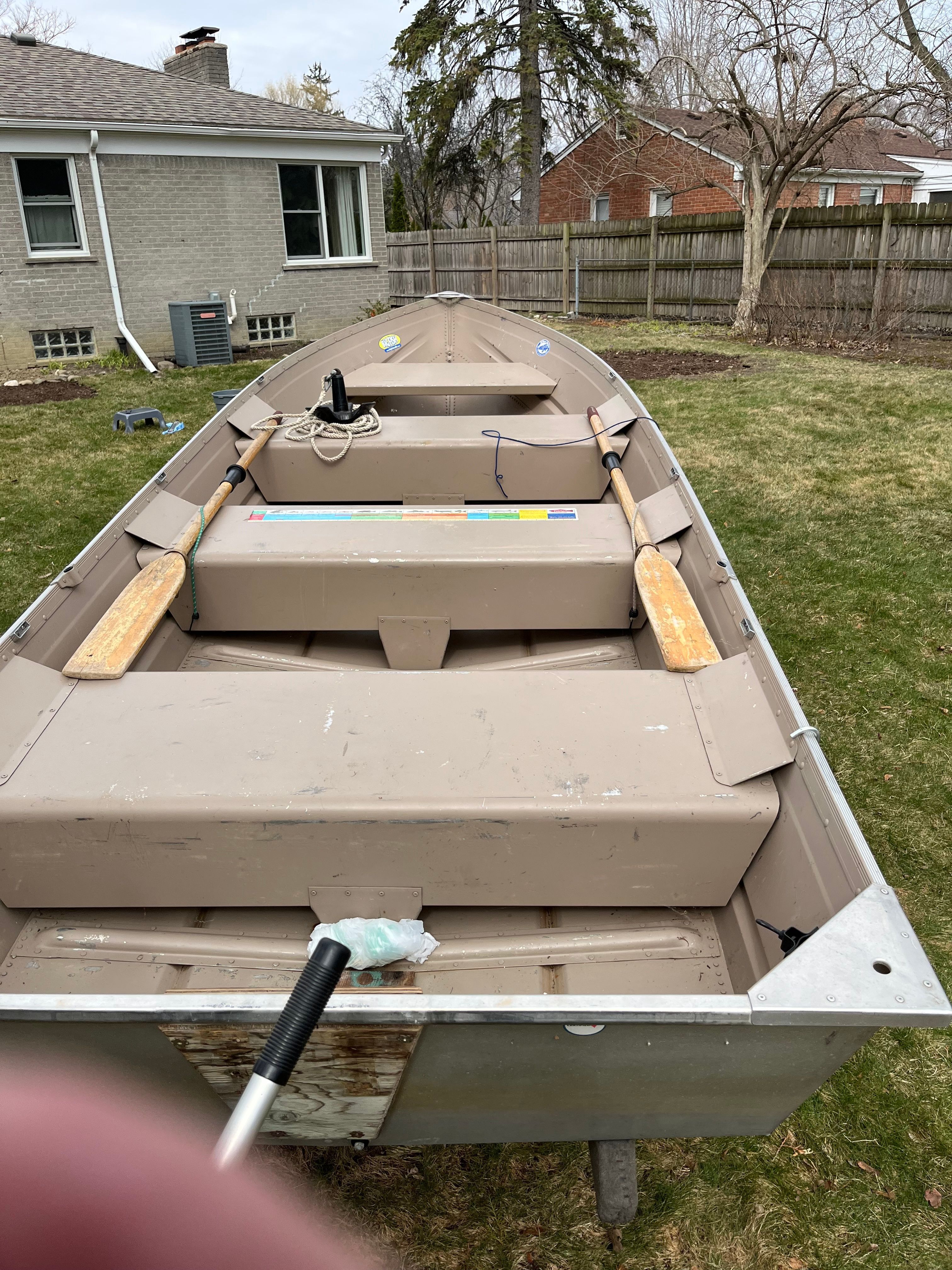 A 2005 Polar Kraft V1460 boat is on a lawn in front of a house.