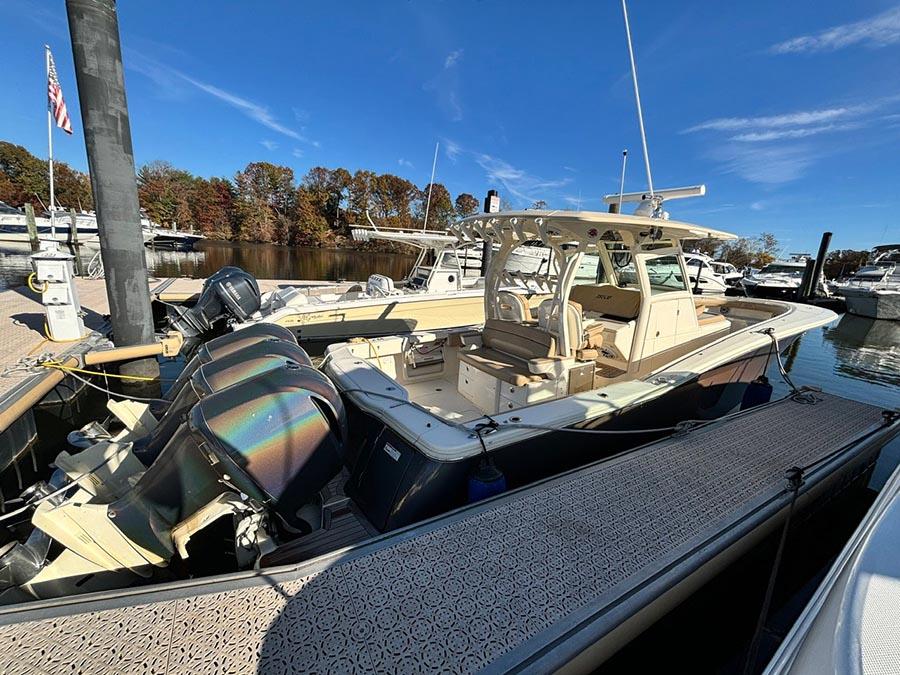 2016 Scout 350 LXF boat docked at marina with triple outboard engines.