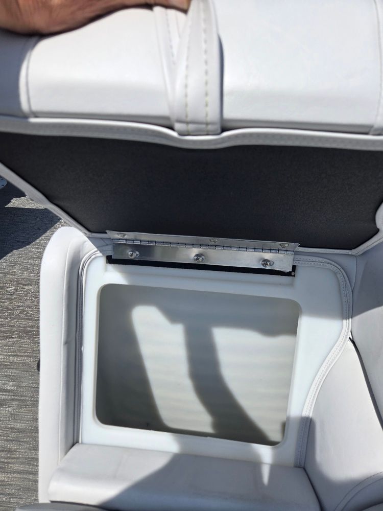 A boat seat with an open storage compartment underneath.
