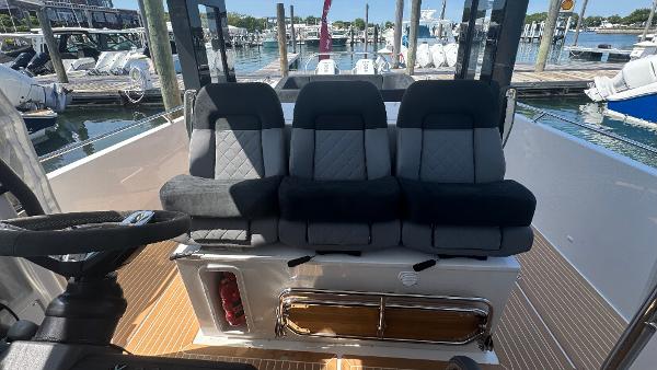 Three cushioned seats on a 2025 Nimbus T11 boat, docked at a marina.