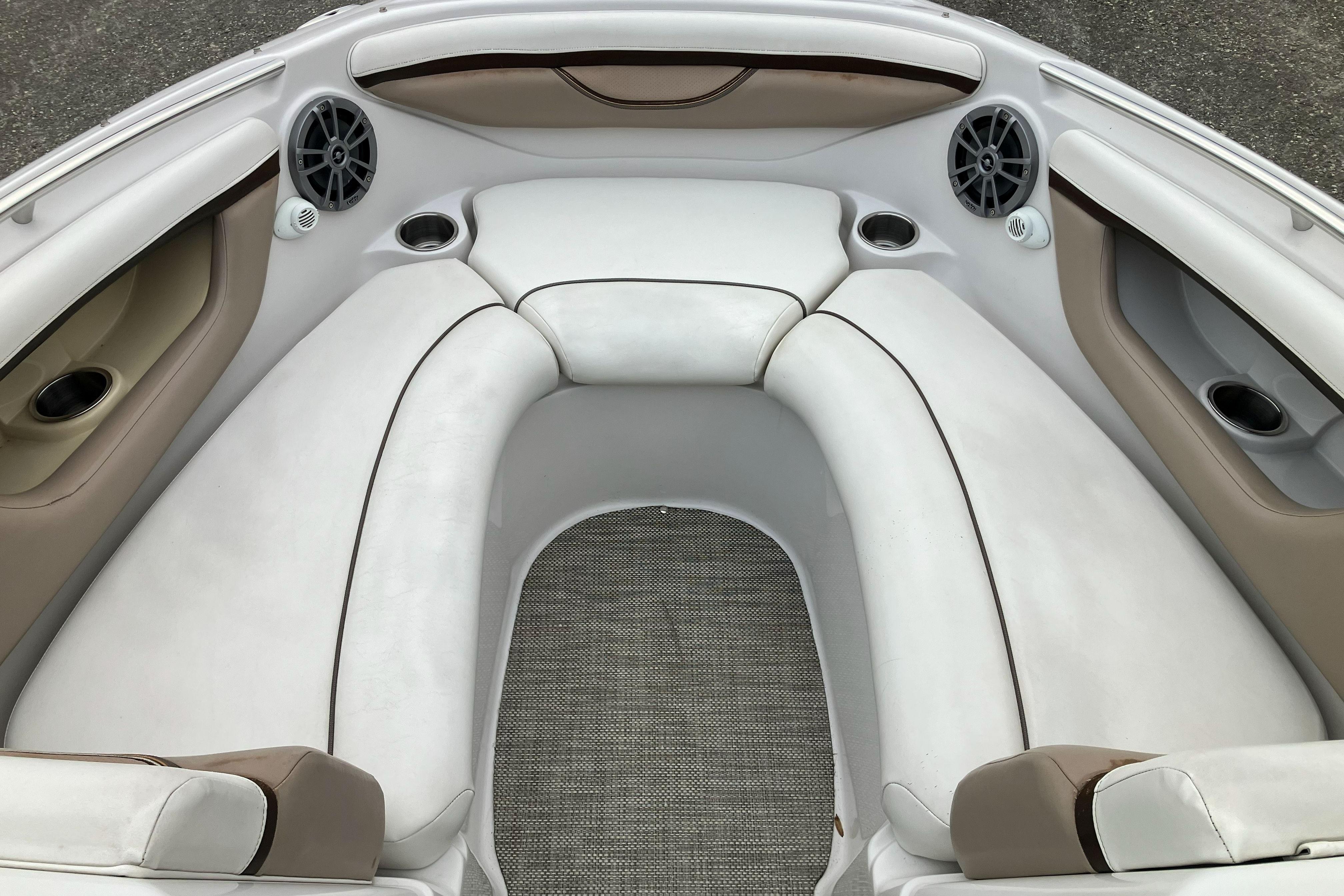 Interior of 2006 Four Winns 240 Horizon boat with white seating and speakers.