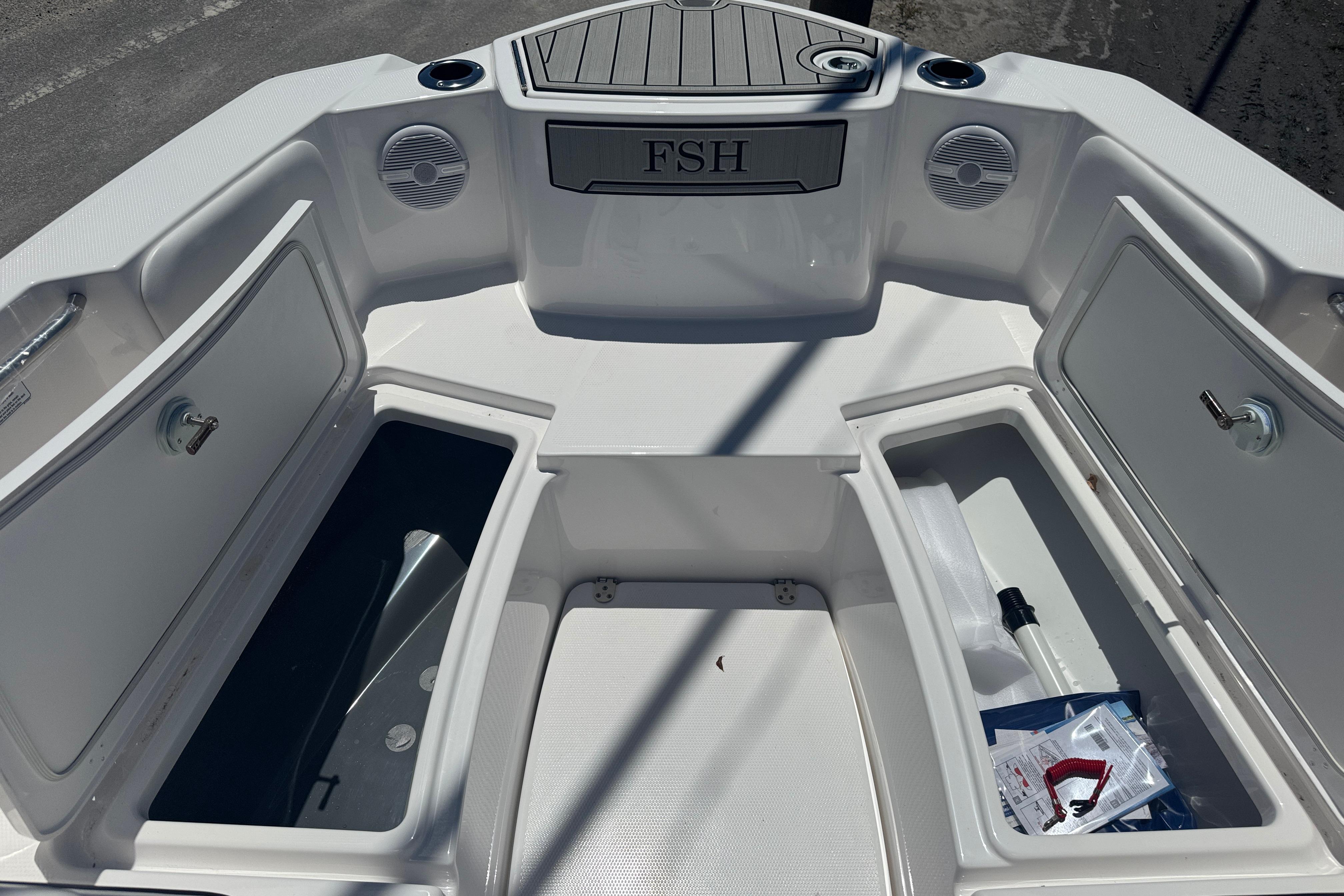 2026 Yamaha Boats 220 FSH Sport interior with open storage compartments and speakers.