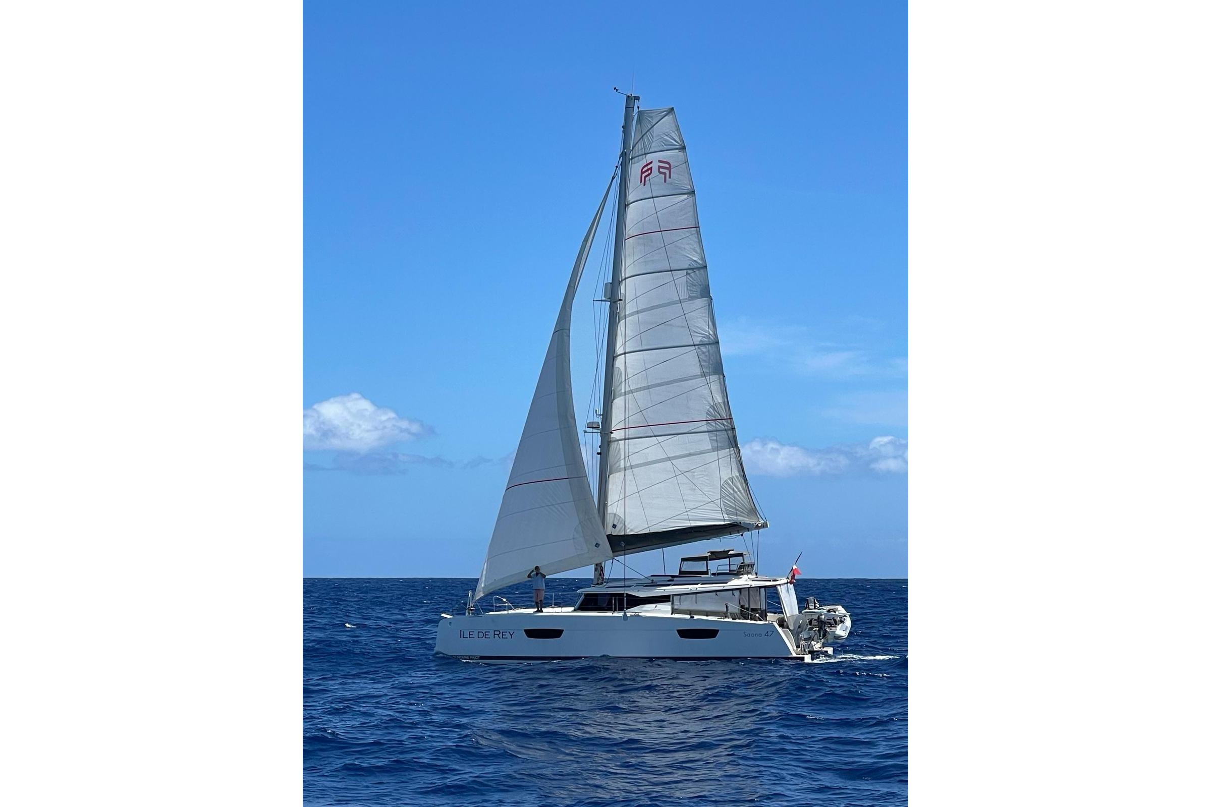 2020 Fountaine Pajot Saona 47 sailing on open sea under clear blue sky.