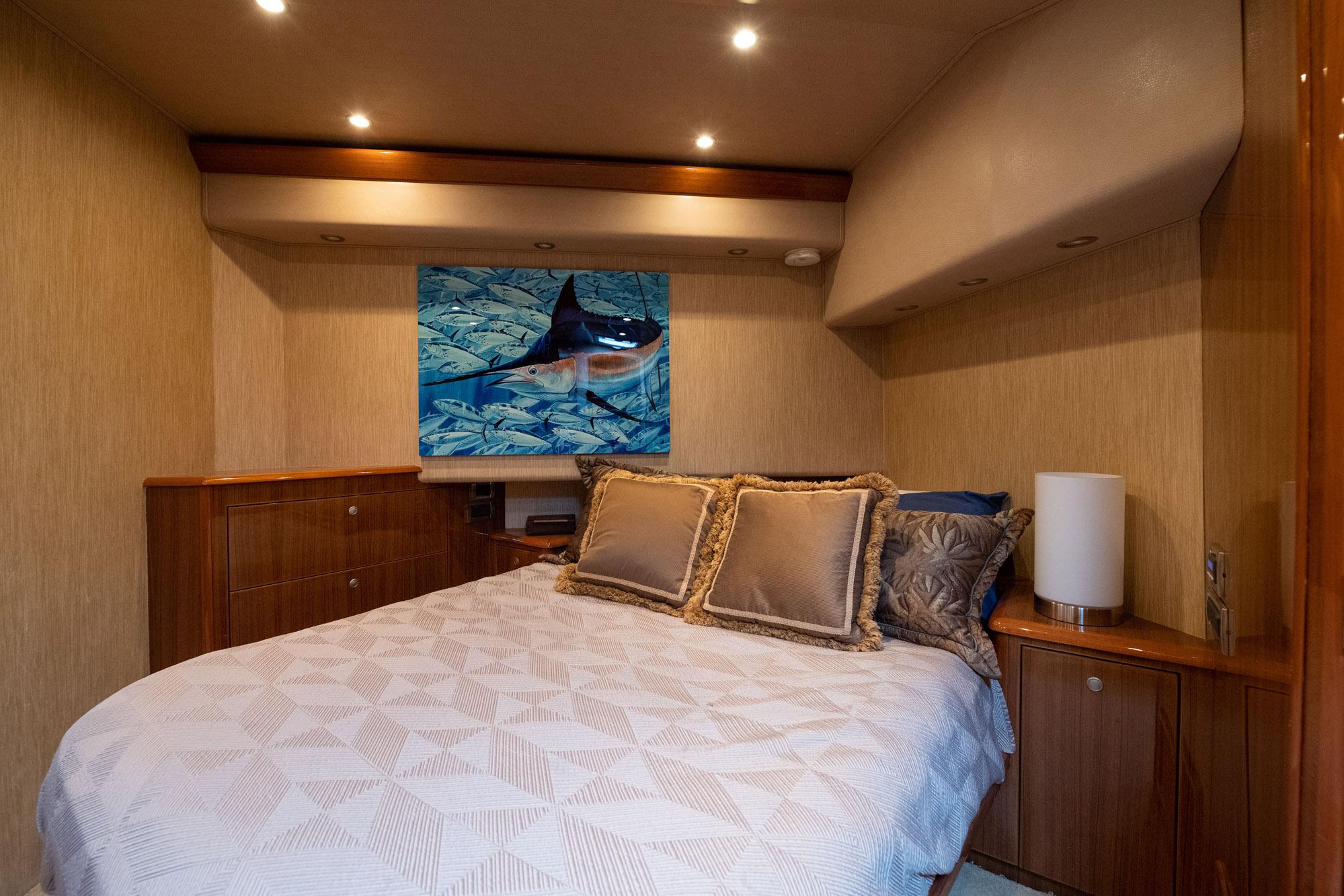 Luxurious bedroom interior of 2007 Viking 64 Convertible yacht with elegant decor and artwork.