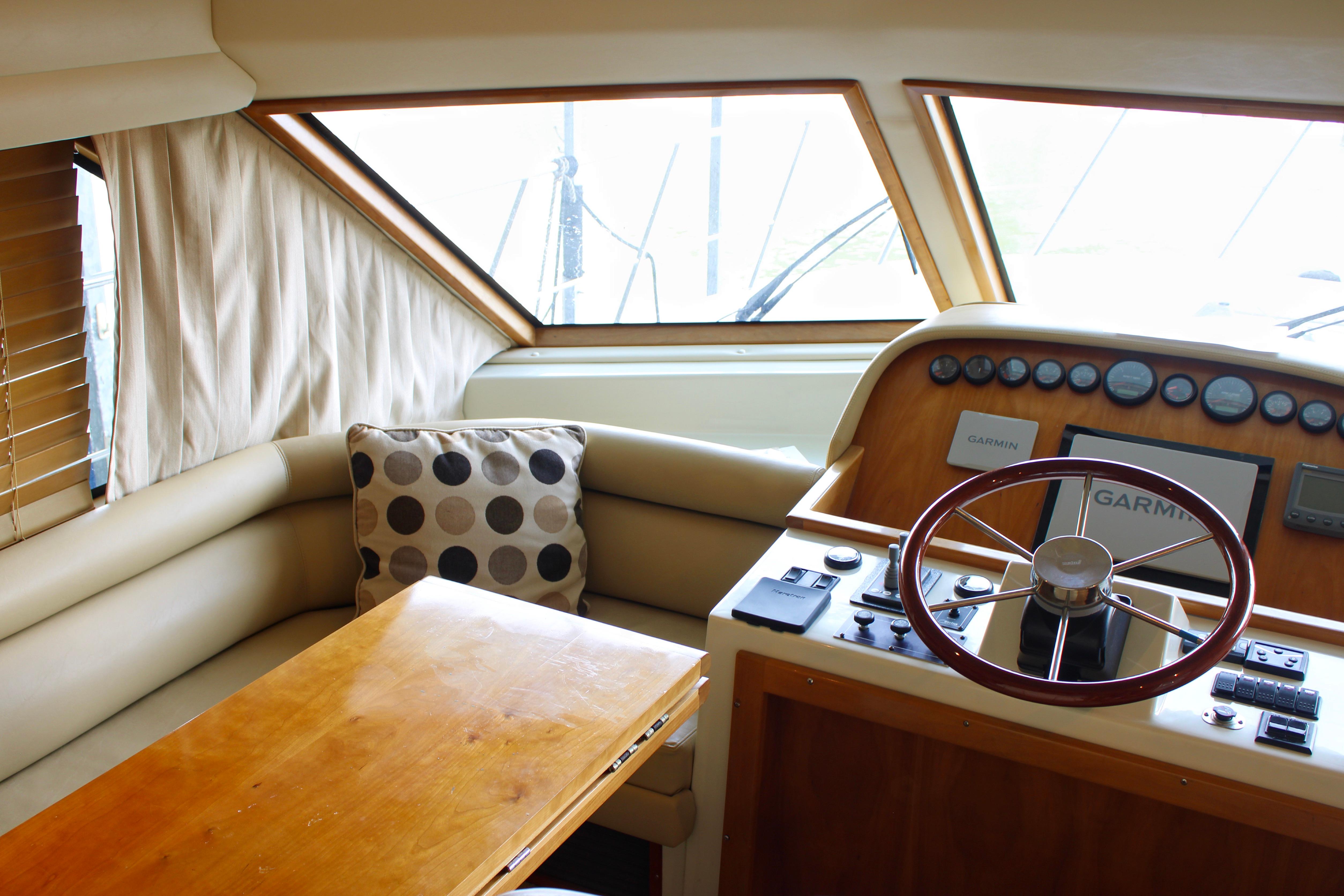 Luxurious 2007 Navigator 5100 yacht interior with helm, steering wheel, and cozy seating area.