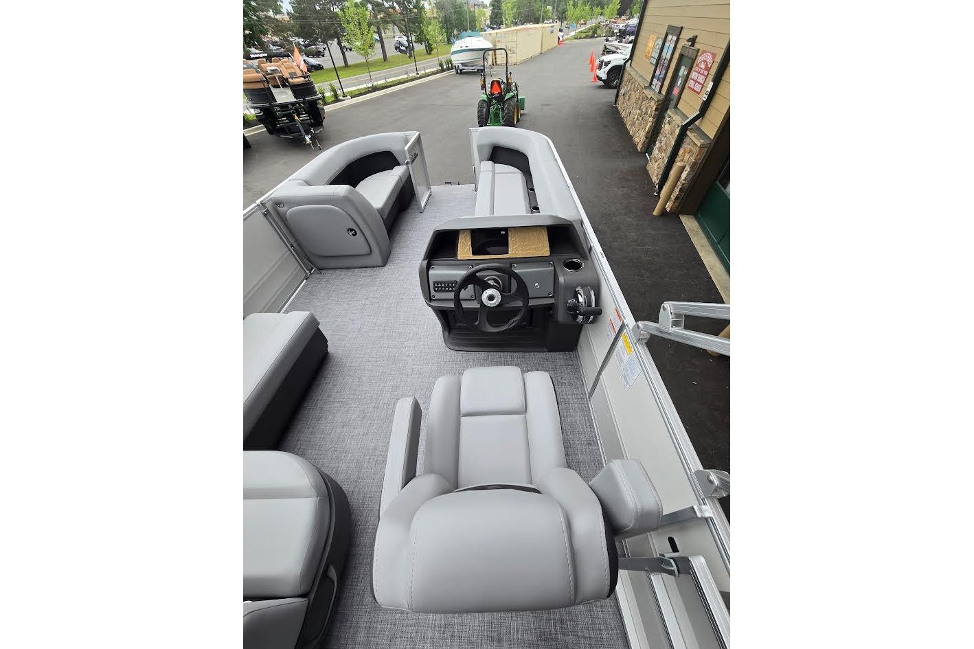 2026 Sun Tracker Party Barge 18 DLX interior with gray seating and steering console.