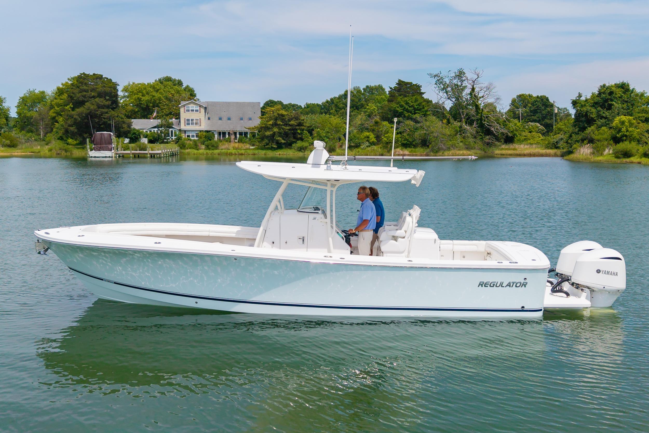 2019 Regulator 31 boat on calm water with lush greenery in the background.