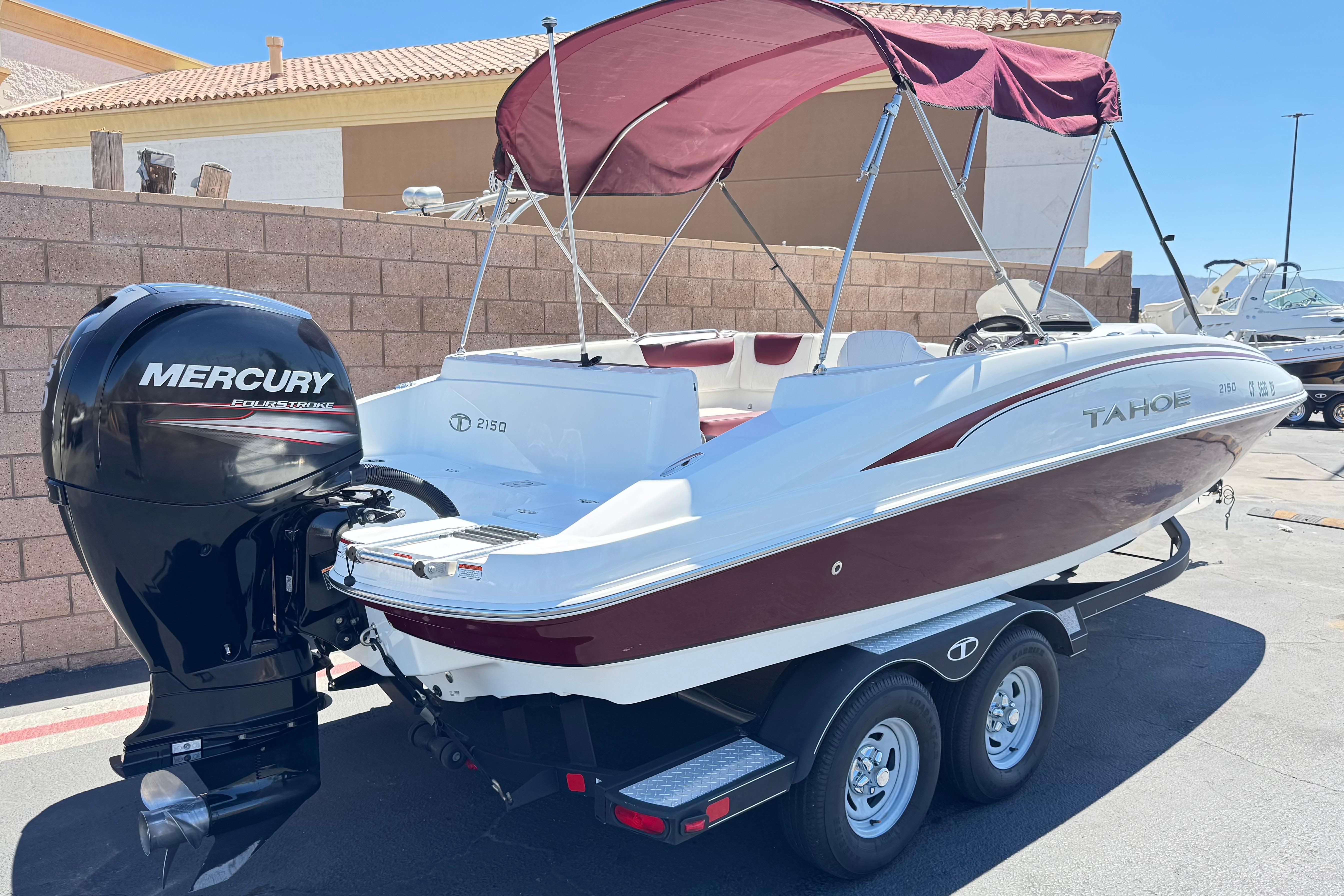 2017 Tahoe 2150 boat with Mercury engine, parked on a trailer under a sunny sky.