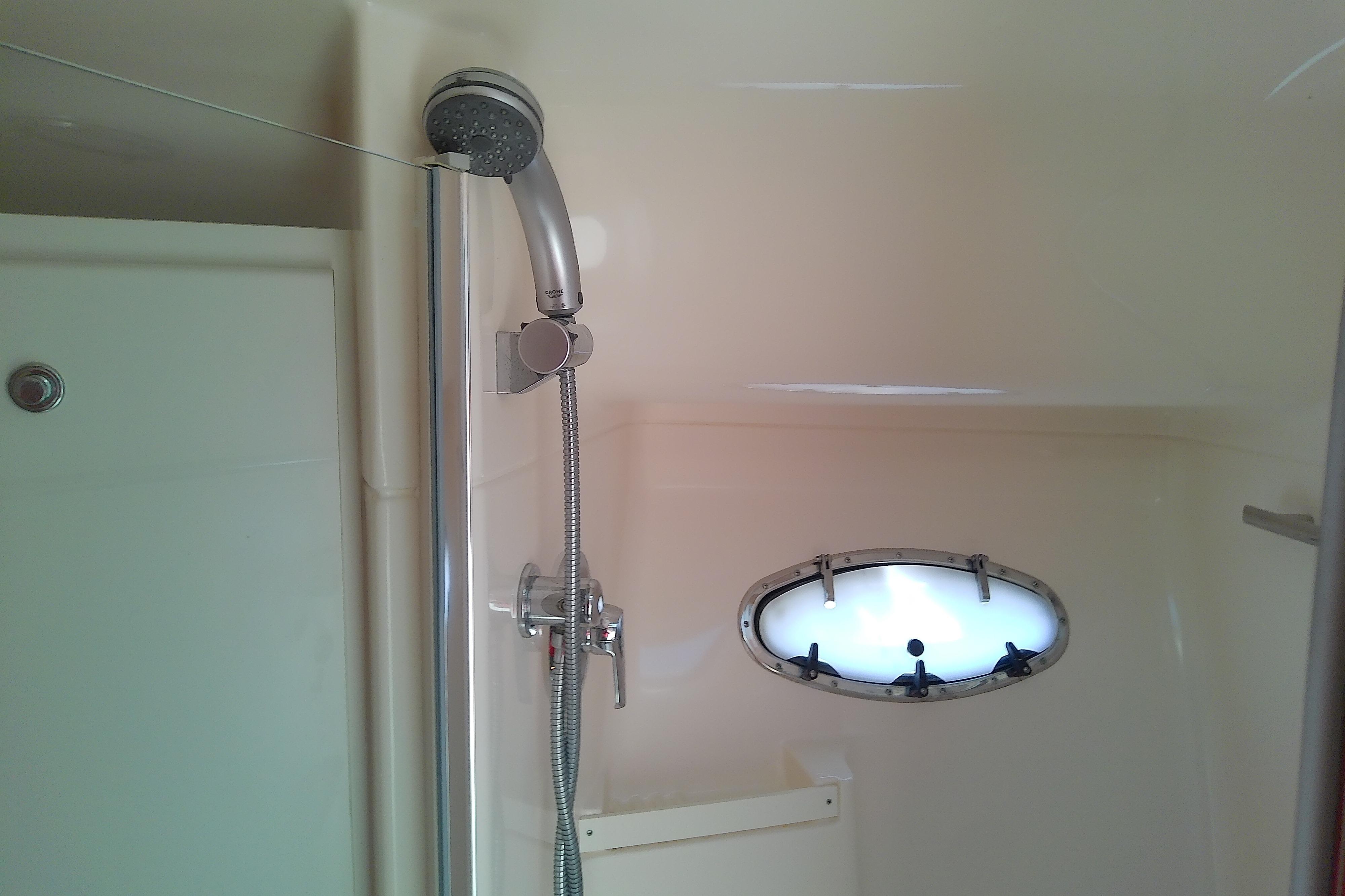 Shower area in 2000 Tiara Yachts 4100 Open, featuring a handheld showerhead and porthole.
