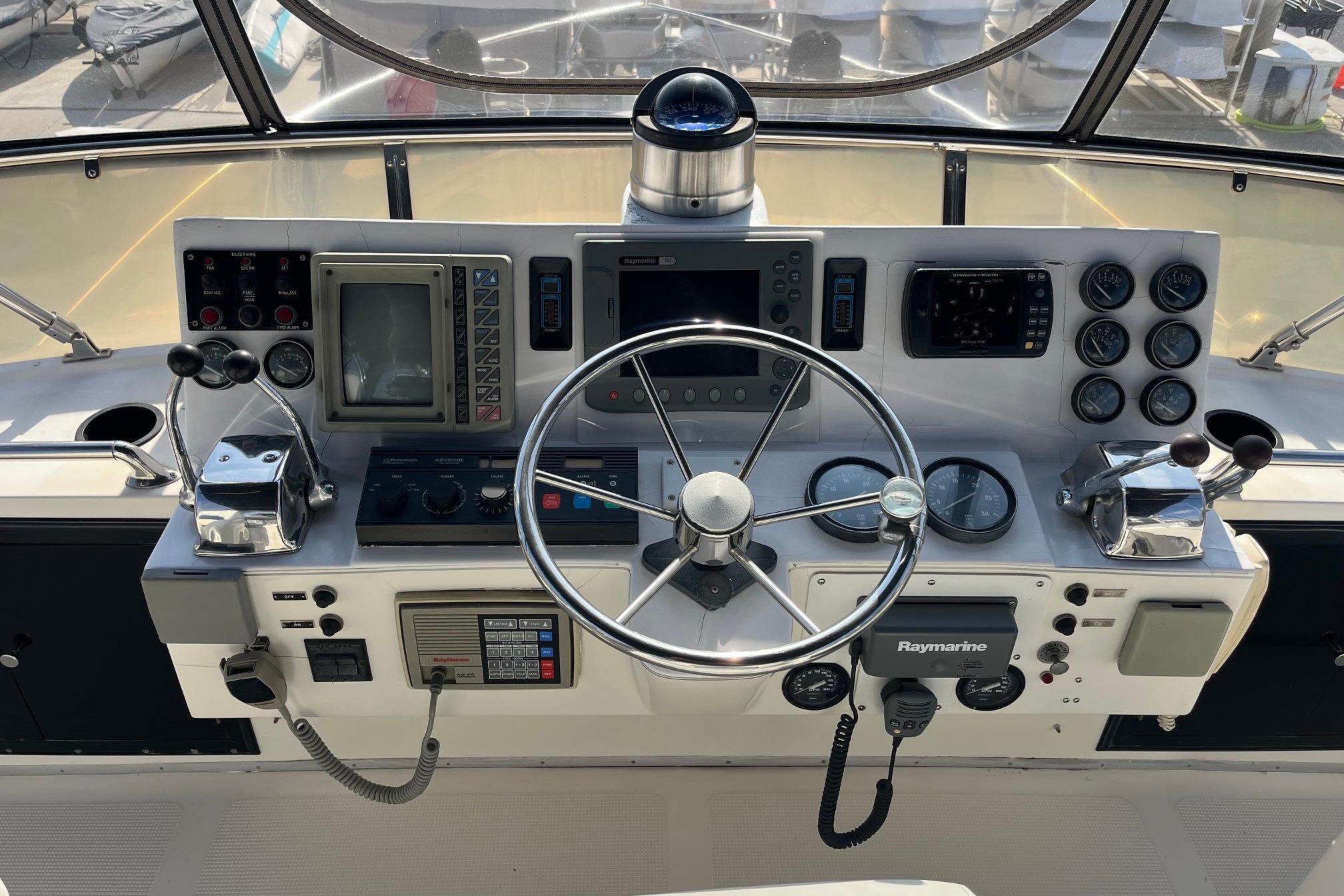 Helm of 1989 Ocean Alexander 440 Sundeck CPMY with navigation instruments and steering wheel.