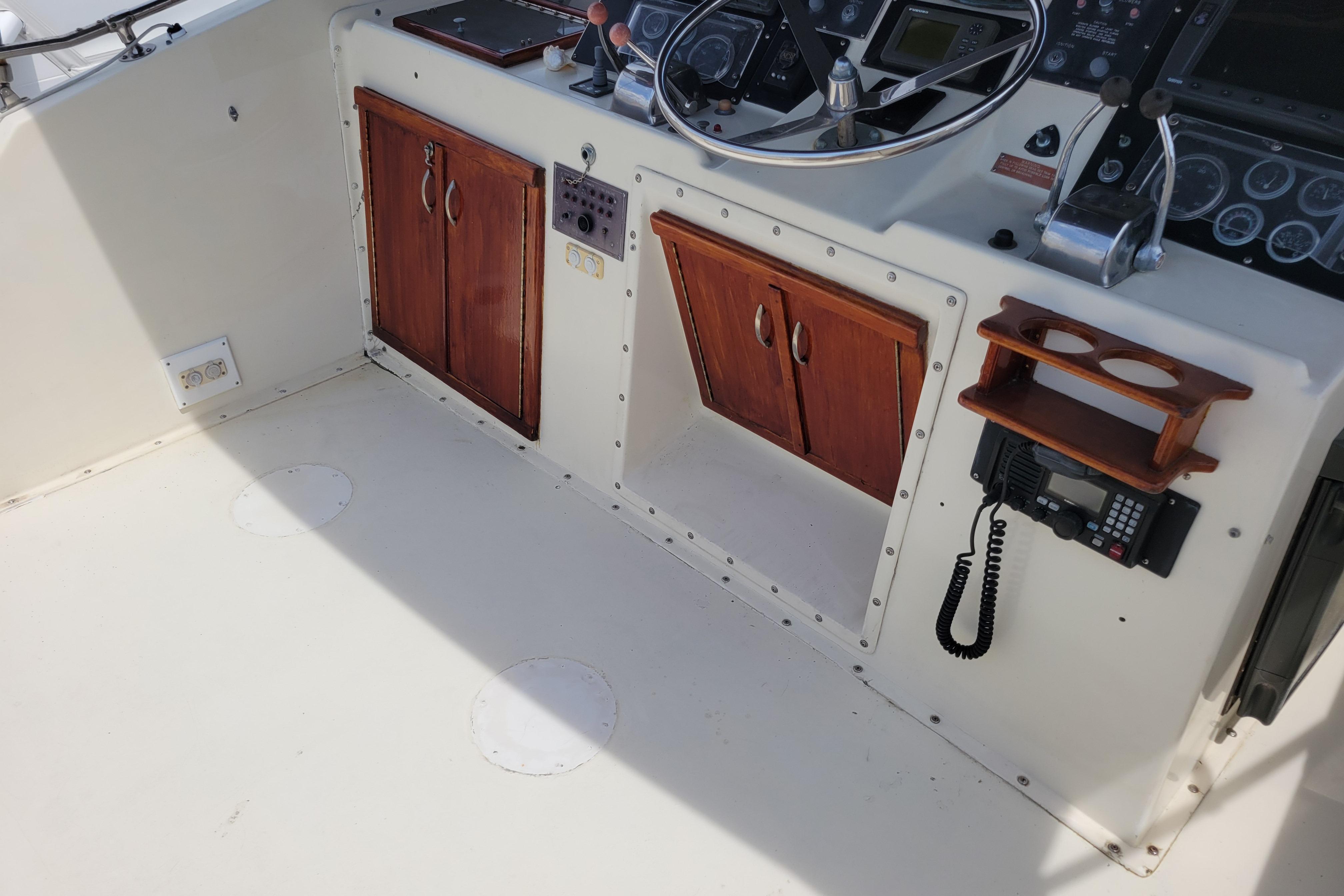 1980 Hatteras 53 Yacht Fisherman helm with wooden cabinets and navigation equipment.