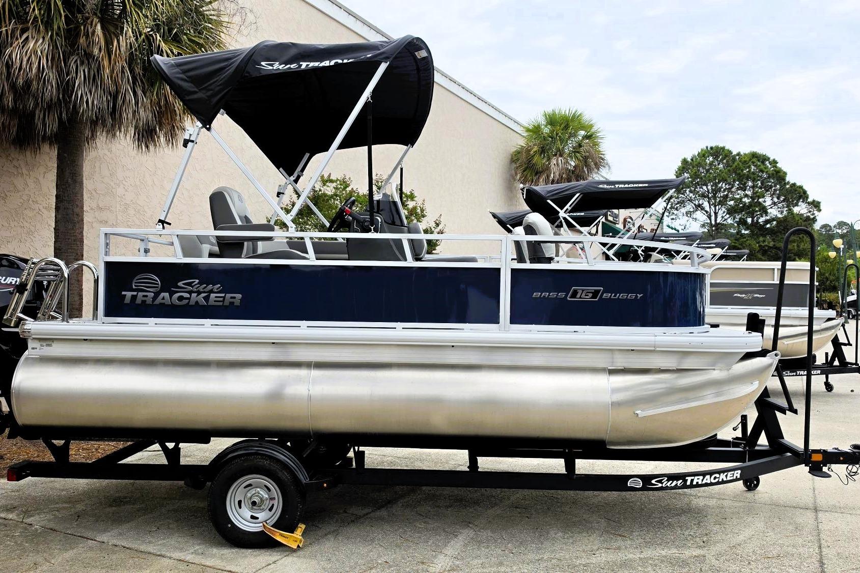 2026 Sun Tracker Bass Buggy 16 XL Select pontoon boat on trailer, outdoor display.