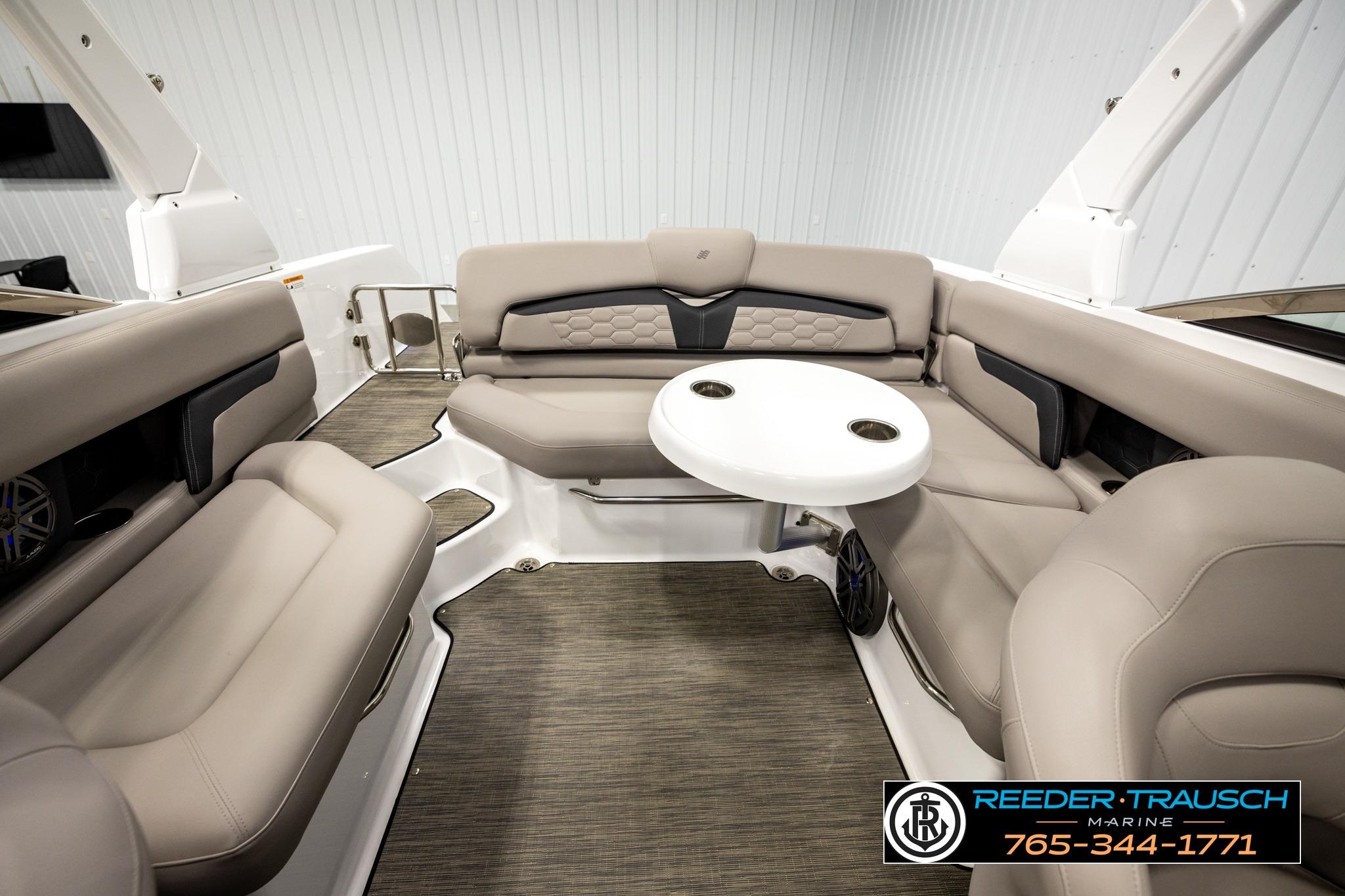 2024 FOURWINNS HD5 Surf boat interior with beige seating and round table.