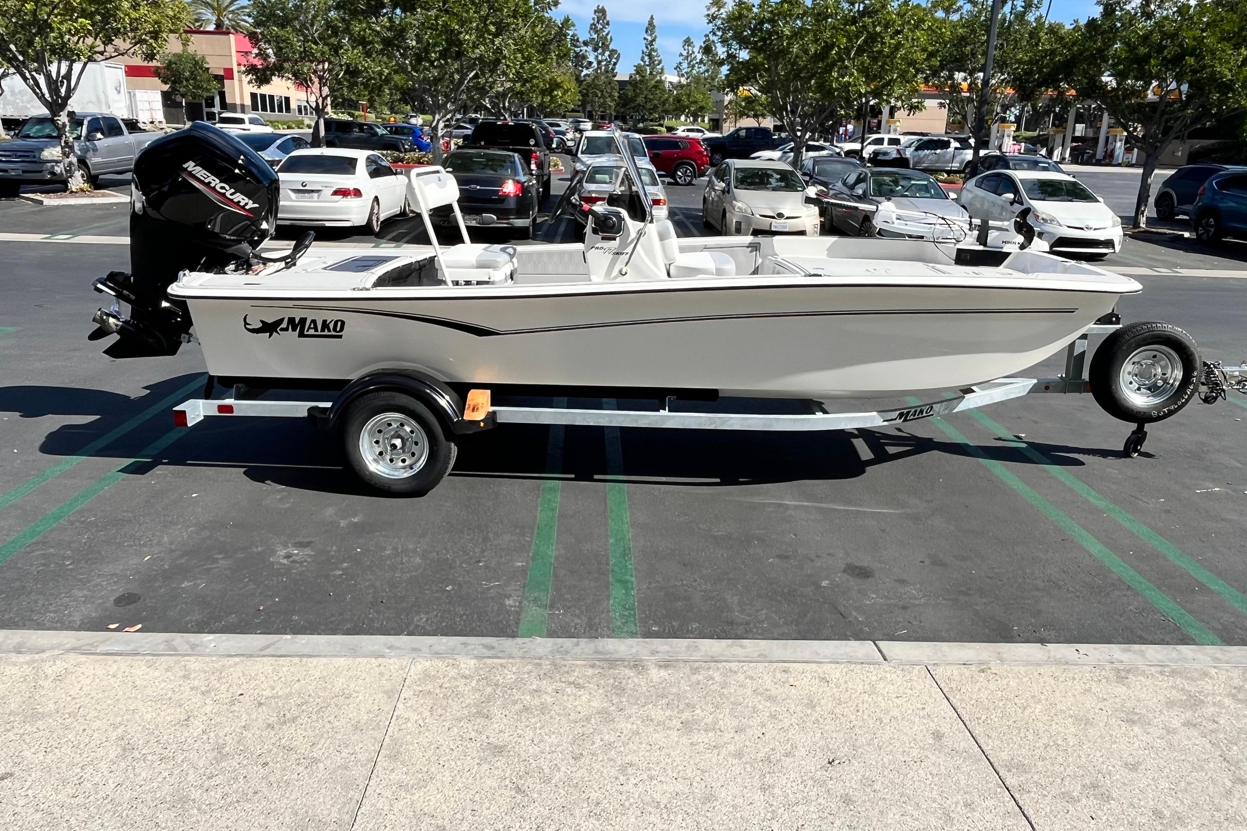 2026 Mako Pro Skiff 17 CC boat on trailer in parking lot.