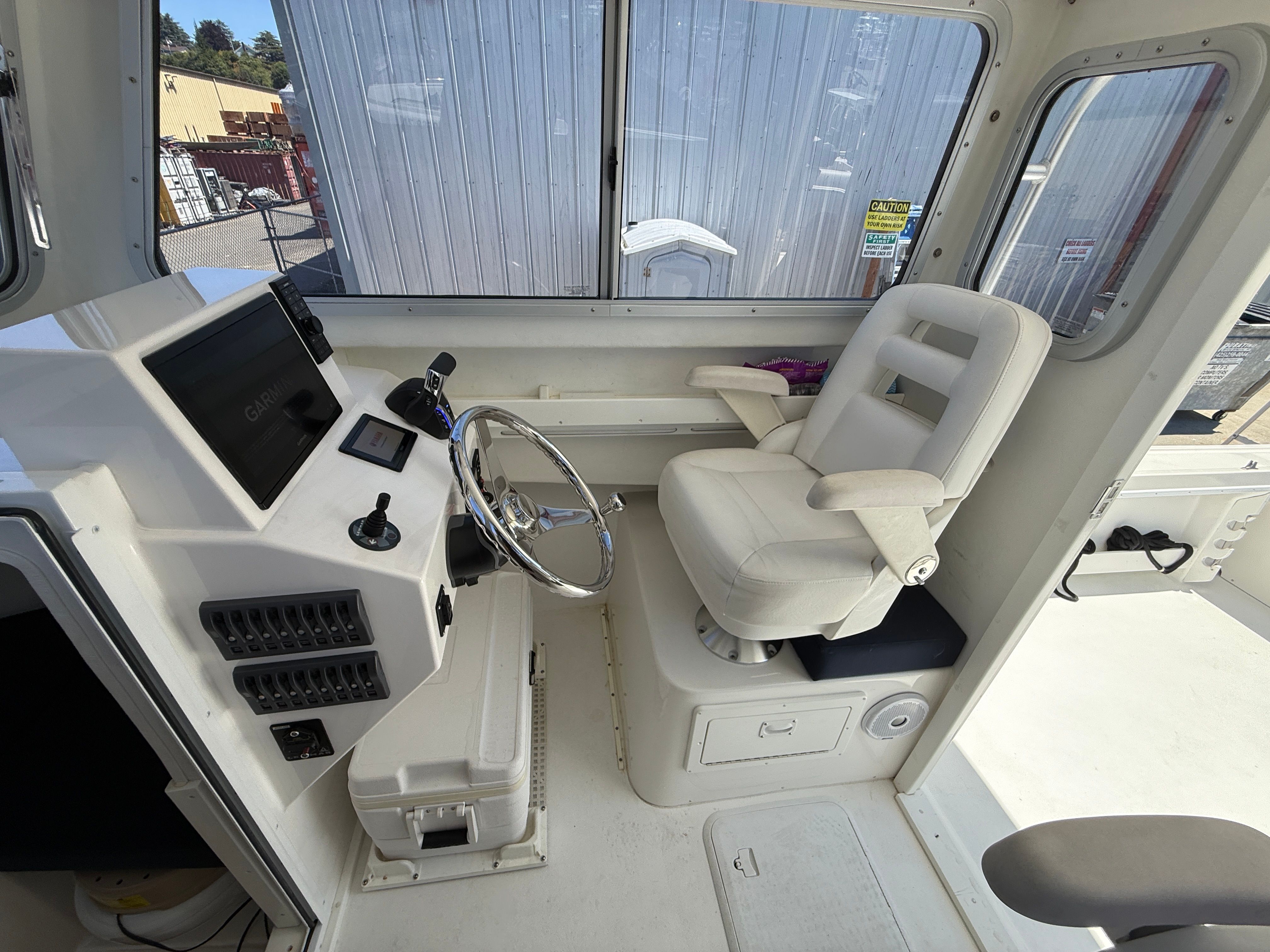 Interior view of a 2015 Steiger Craft 255 Chesapeake with helm and seating.