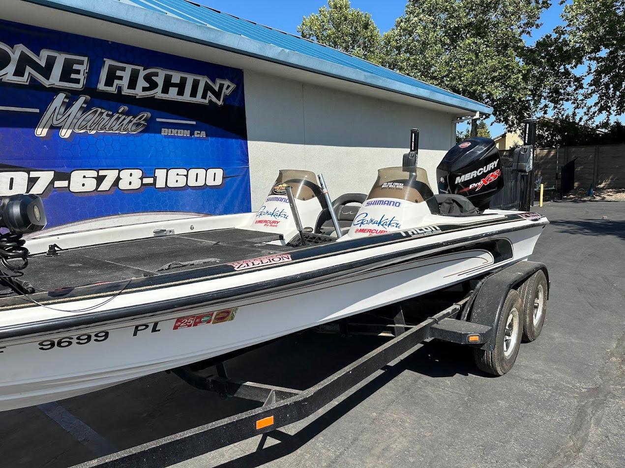1999 Fisher 21 FX DC boat on trailer, parked outside a marine shop.