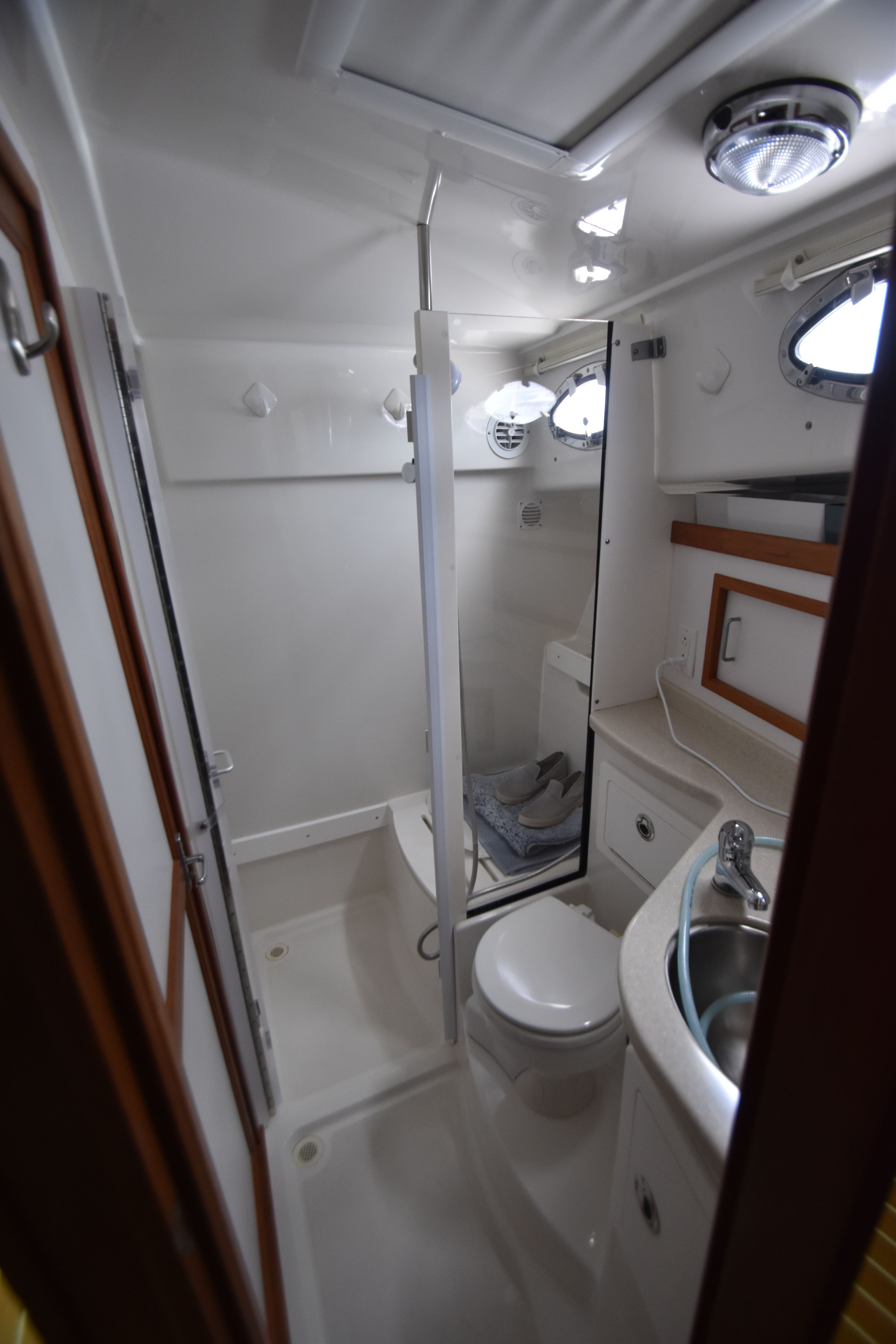 The bathroom of a 2009 Back Cove 37 with a toilet, sink, and shower.