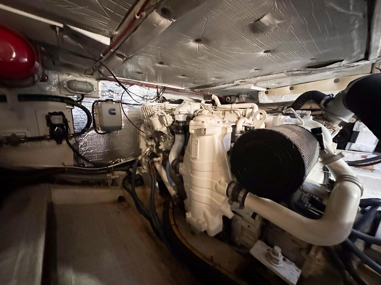 Engine room of 2000 Legacy Yachts 40 Sedan, showcasing mechanical components and wiring.