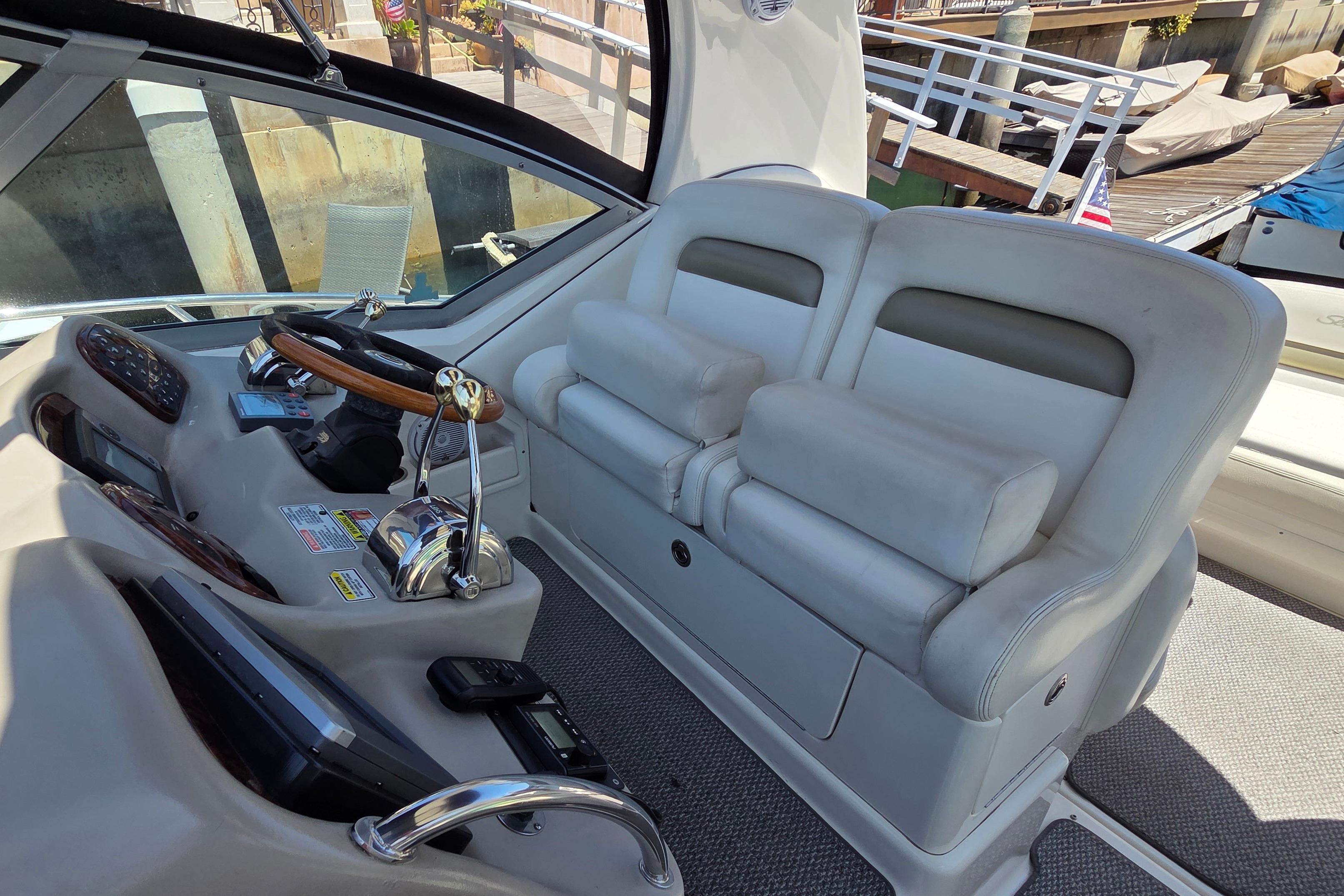 2006 Sea Ray Sundancer 320 helm with dual seats and wooden steering wheel.