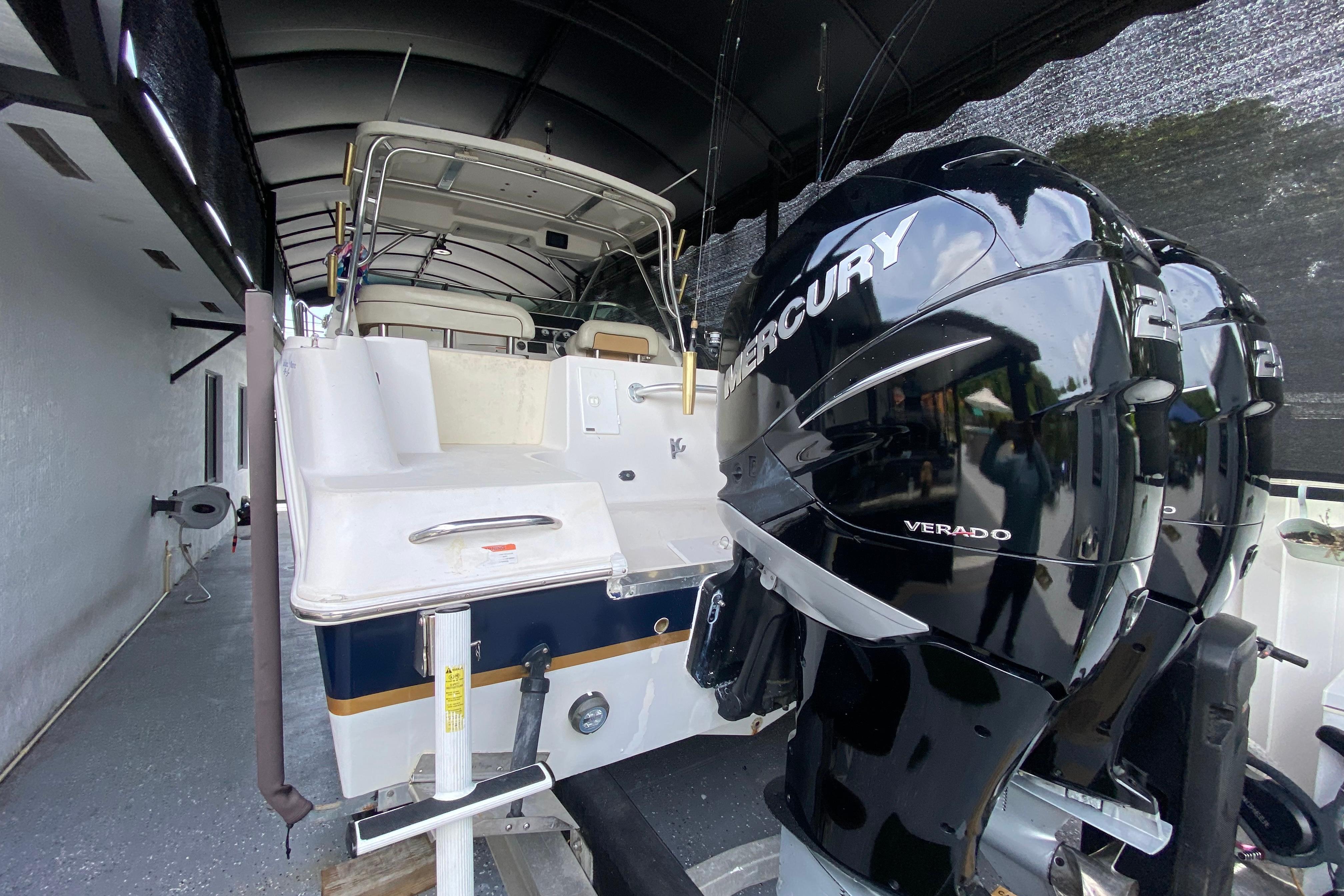 2005 Wellcraft 290 Coastal boat with dual Mercury Verado engines in a covered storage area.