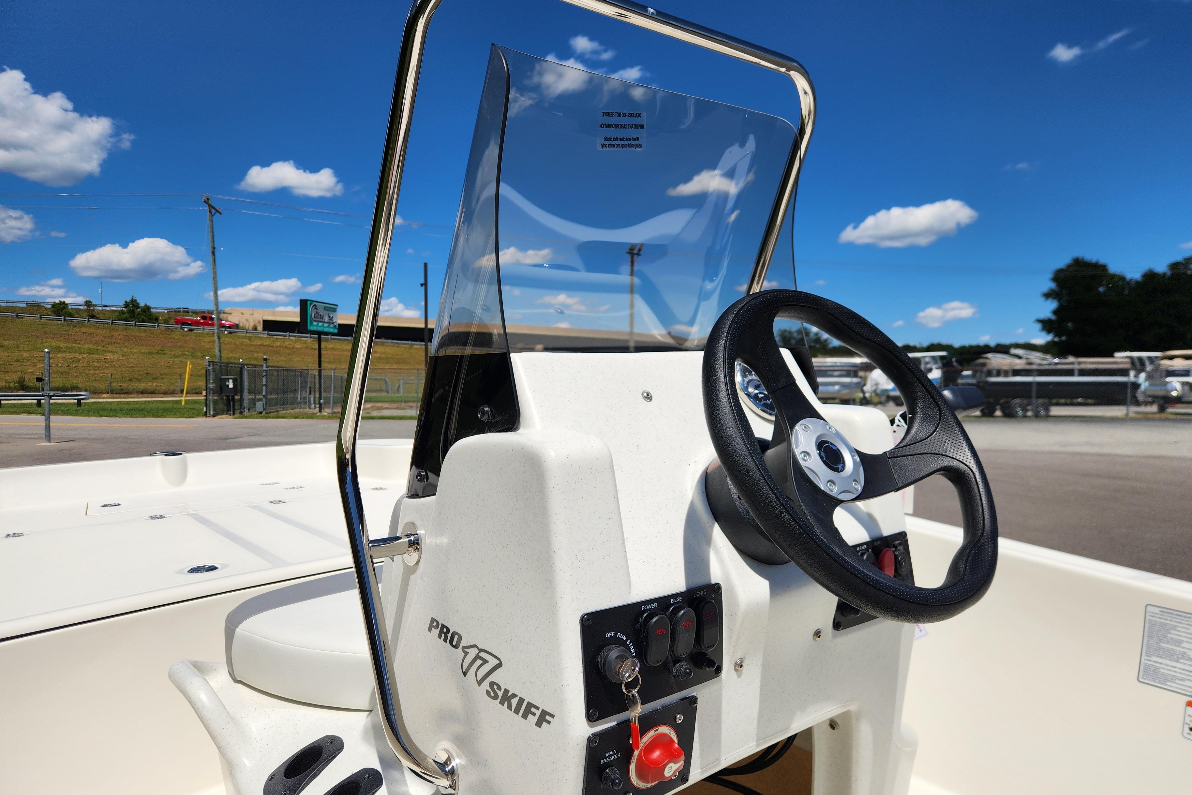 2026 Mako Pro Skiff 17 CC boat console with steering wheel under clear blue sky.