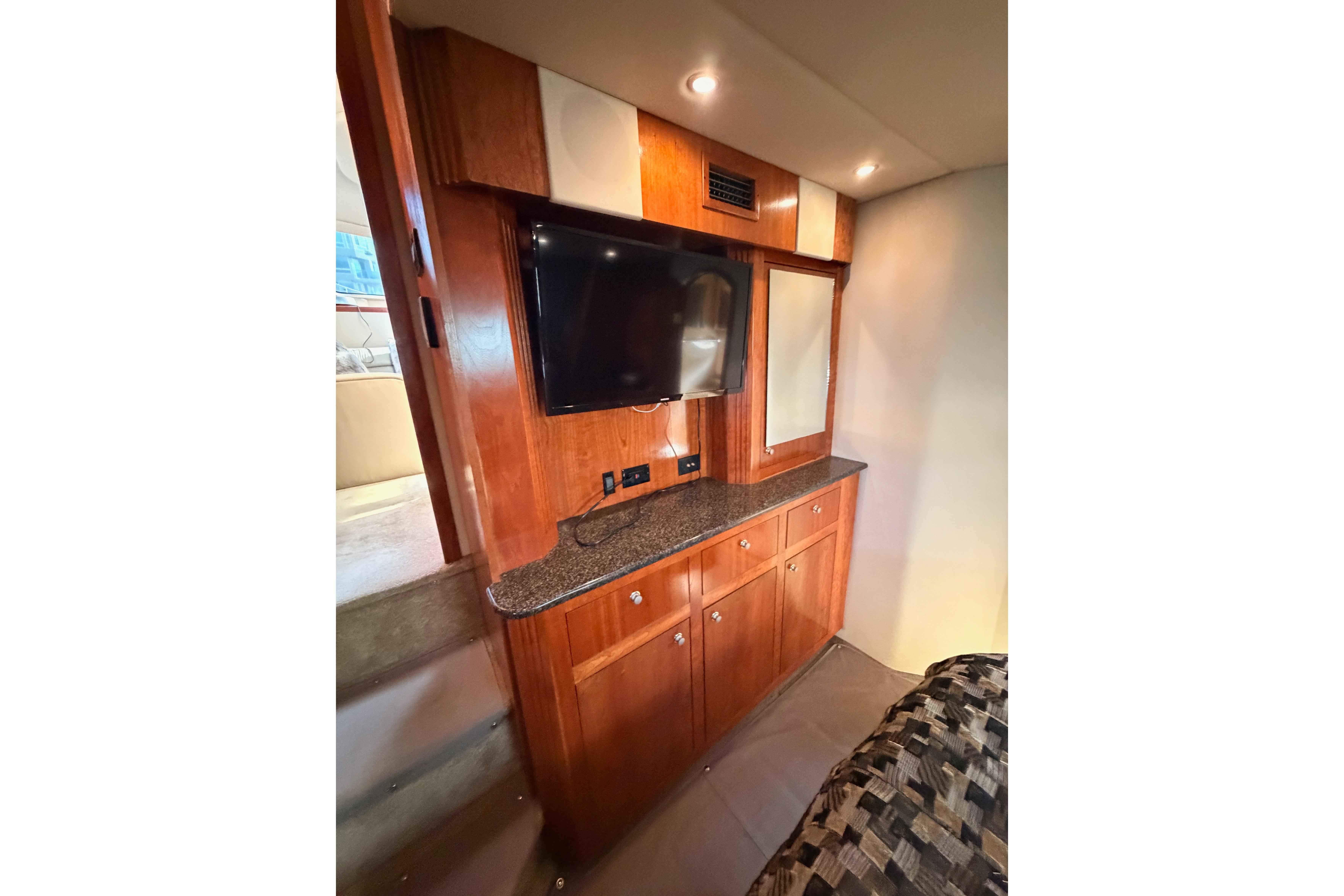 Interior of 2005 Cruisers Yachts 405 Express Motoryacht with TV and wooden cabinetry.