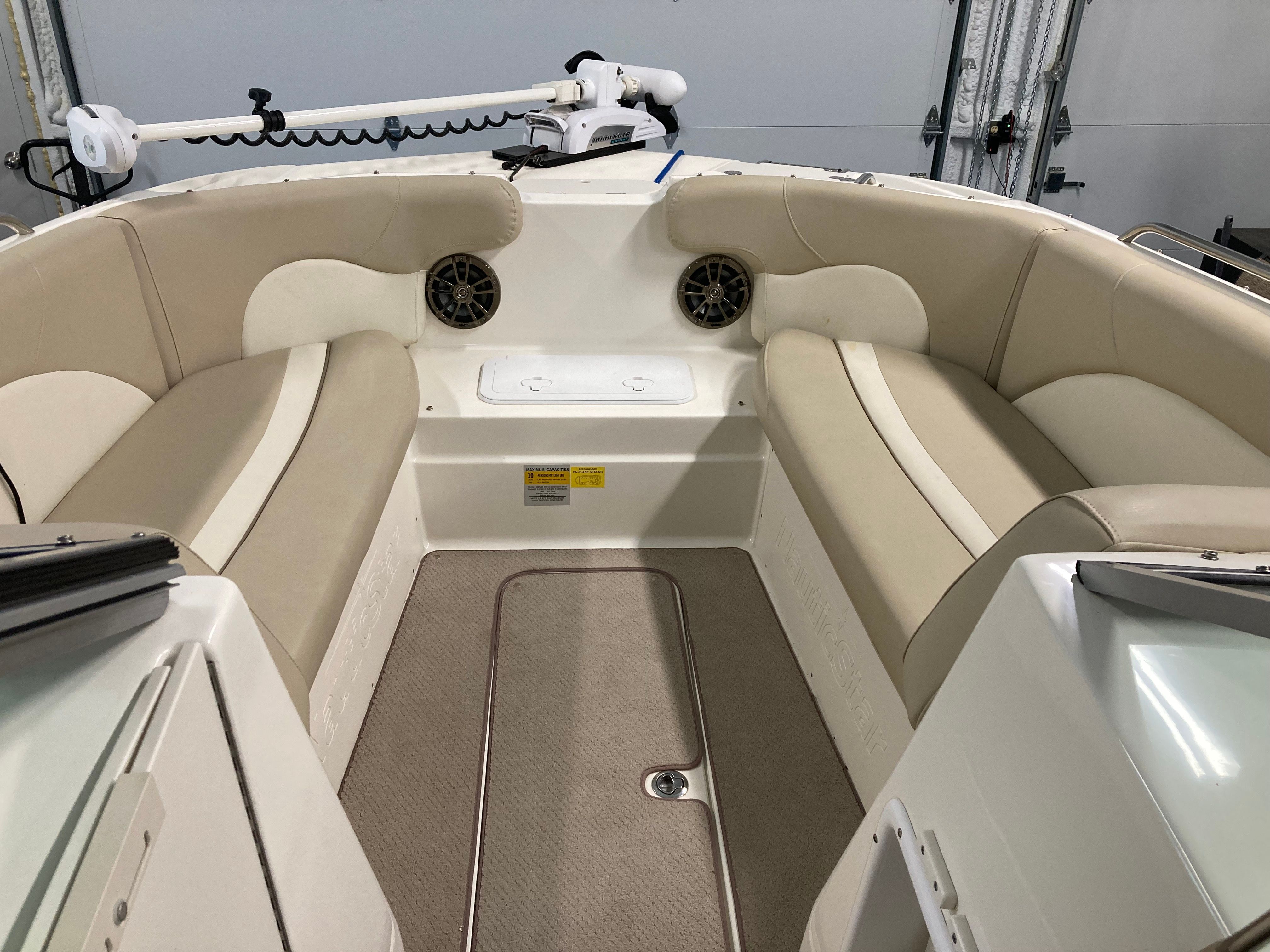 Interior of a 2016 Custom 223 DC boat with beige seating and speakers.