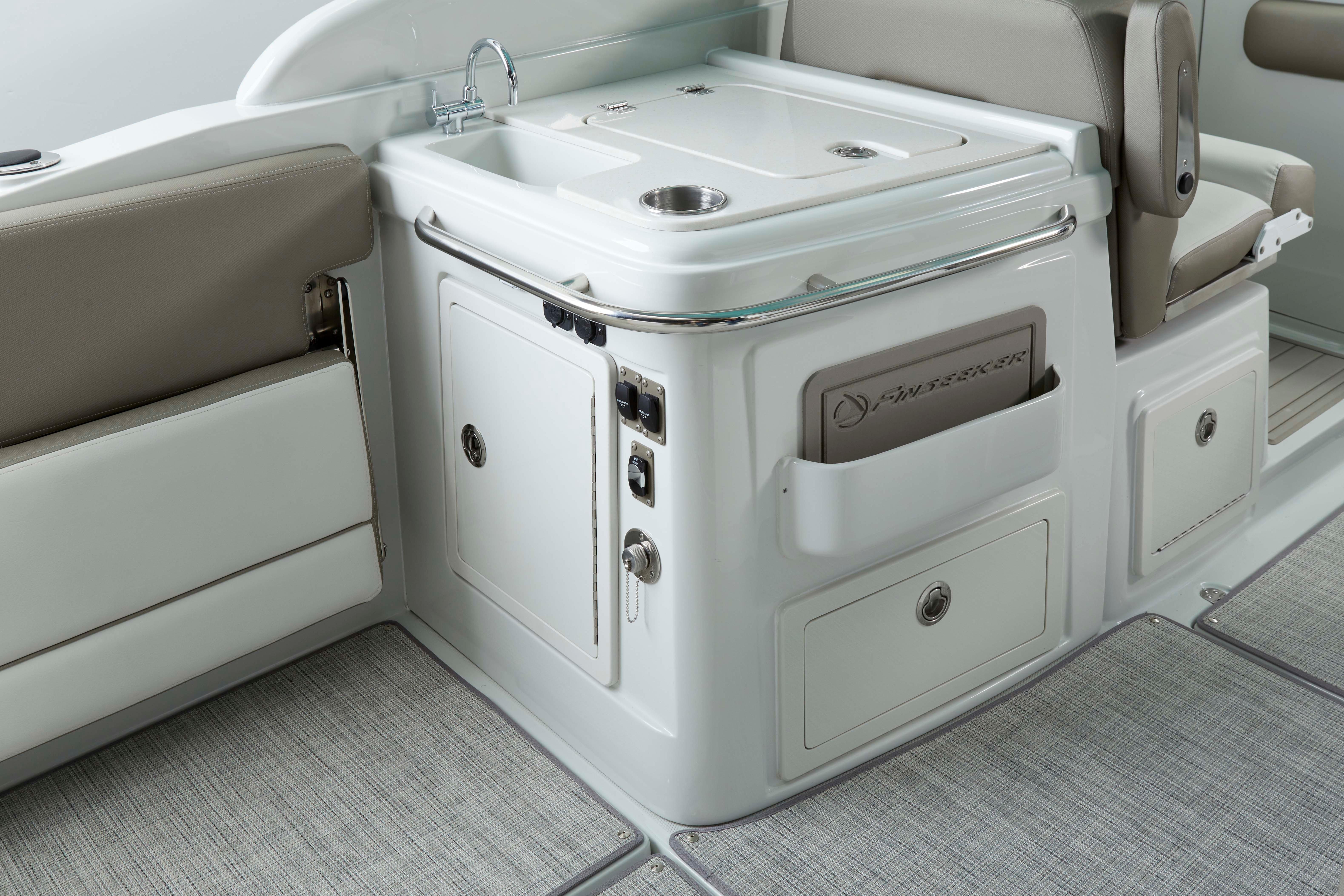 2024 Finseeker 280 DC boat interior with sink, storage, and seating.