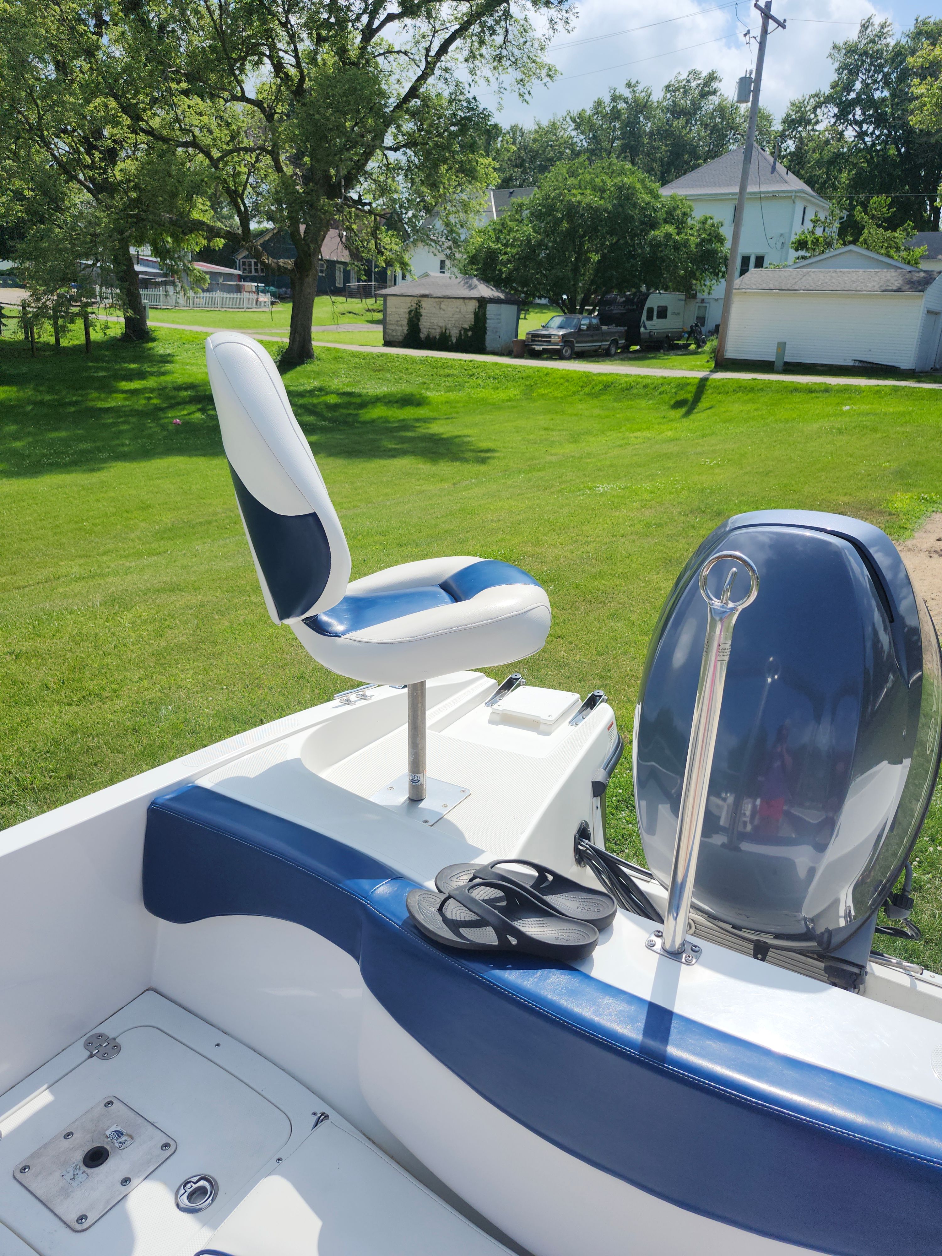 A 2013 Rinker 186 Captiva fish/ski boat with blue and white seats and an outboard motor.