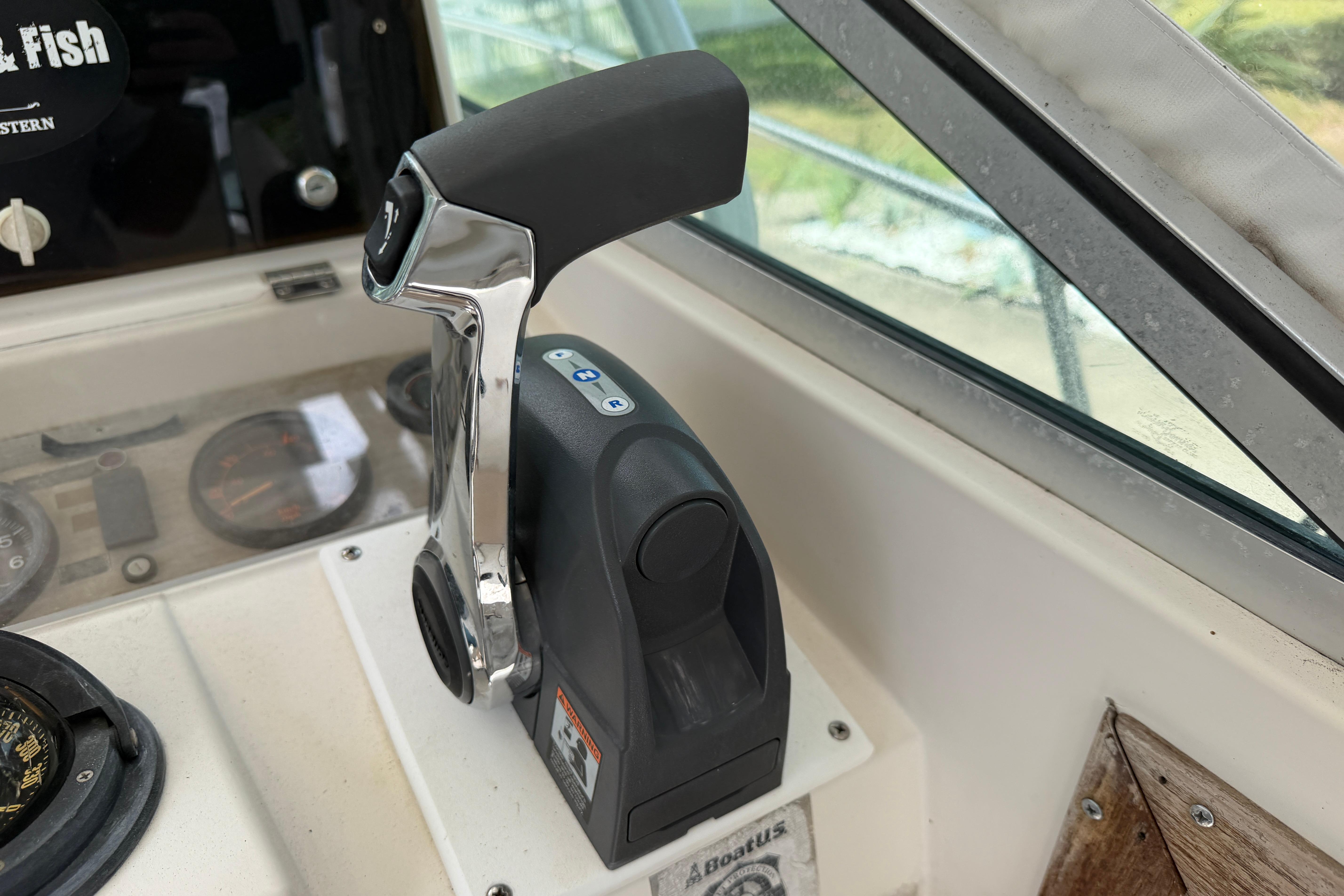 Throttle control on 1987 Grady-White Seafarer 226 boat dashboard, near compass and gauges.