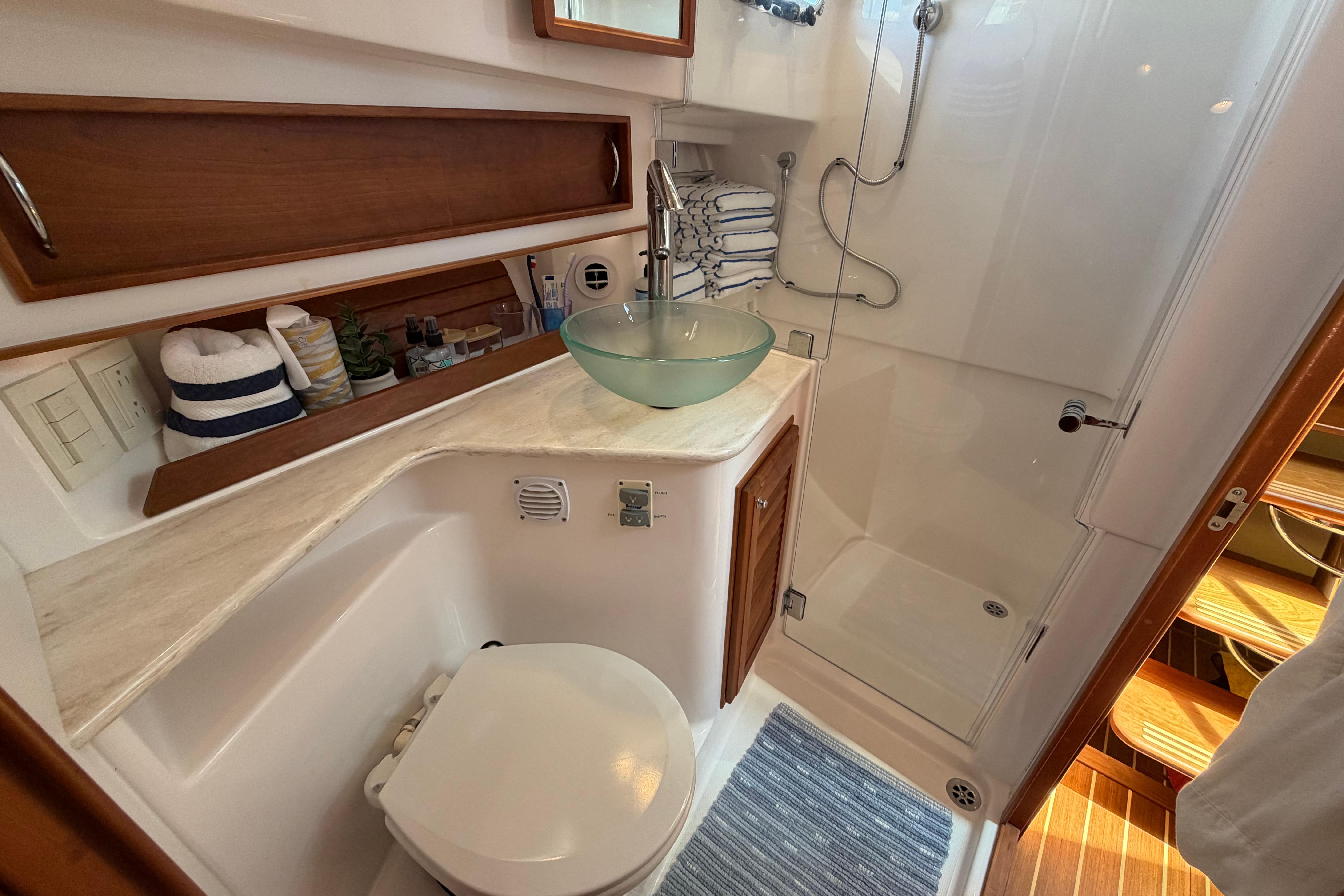 Luxurious bathroom in 2015 Sabre 38 Salon Express yacht with glass sink and shower.