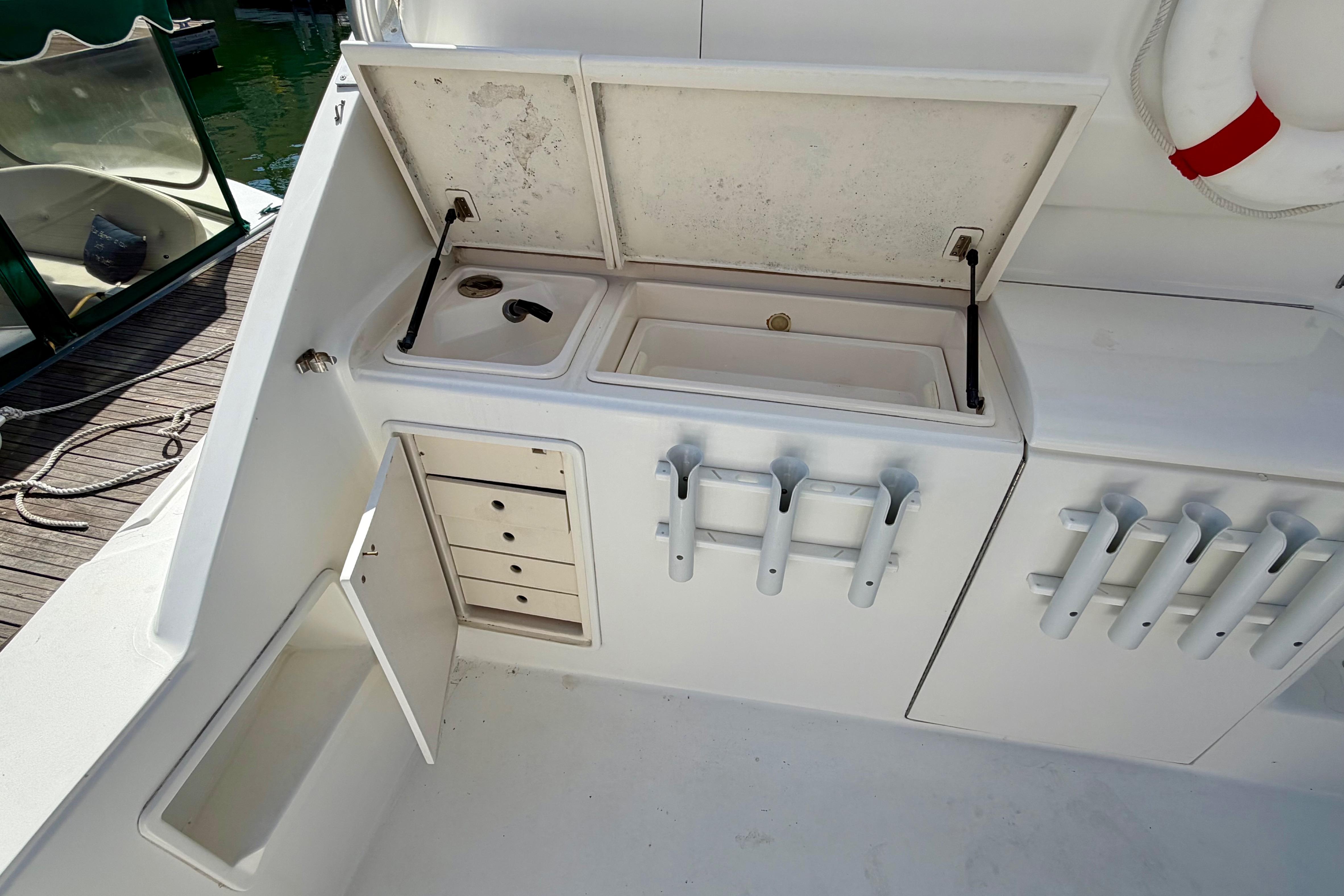 1999 Ocean 40 Express boat deck with storage compartments and fishing rod holders.