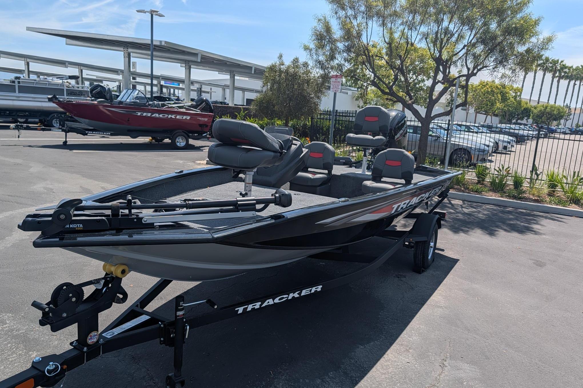 A Tracker Pro Team 175 Crappie Edition boat on a trailer in a parking lot.