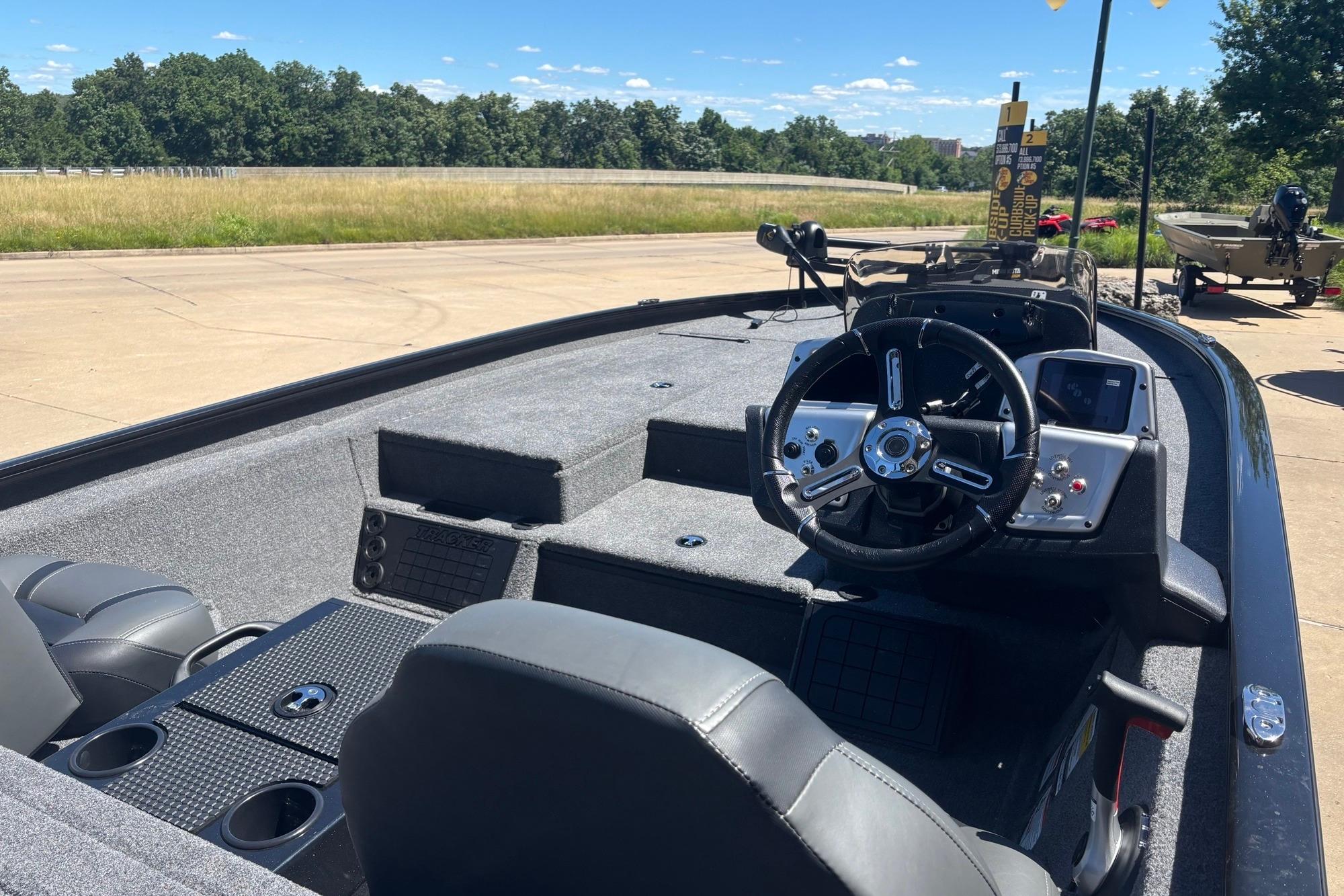 2026 Tracker Savage 215 boat interior with steering wheel and dashboard, parked outdoors.