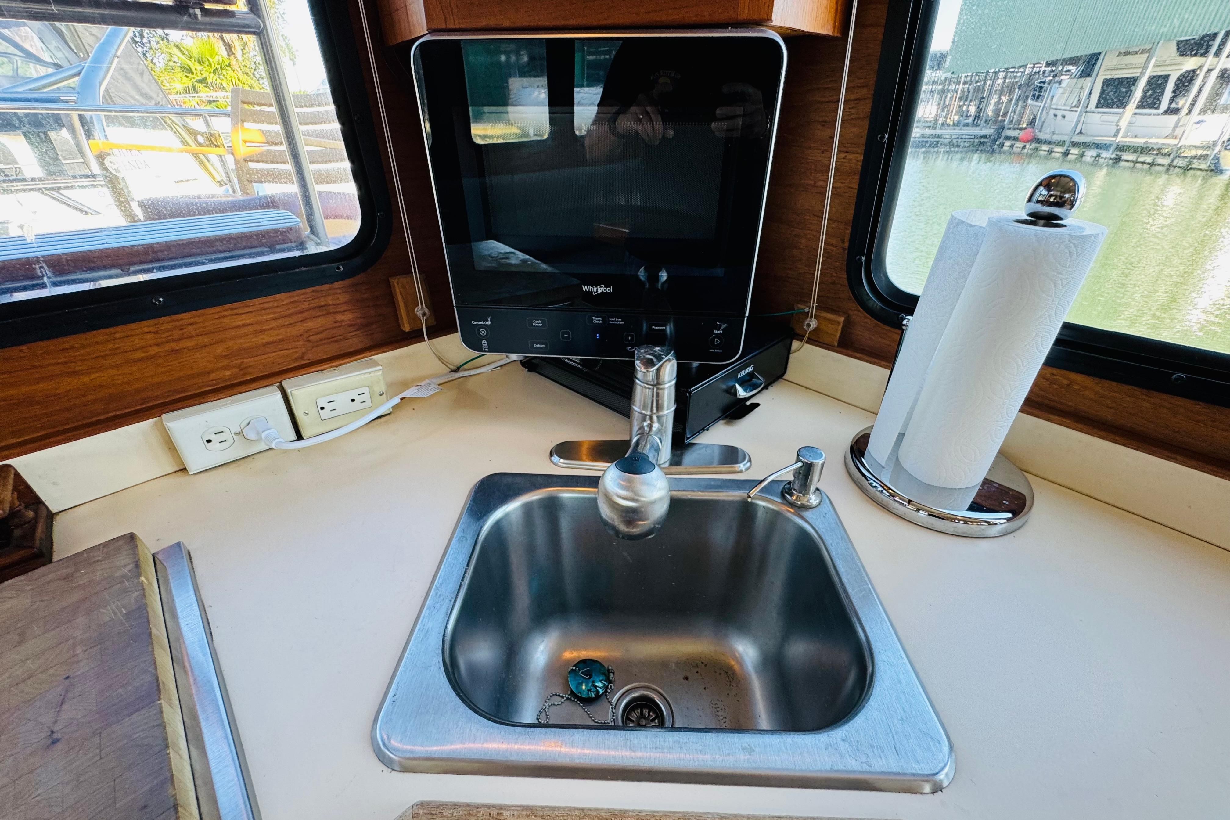 Kitchen sink area in a 1996 Nordic Tug 32, featuring a stainless steel sink and paper towel holder.
