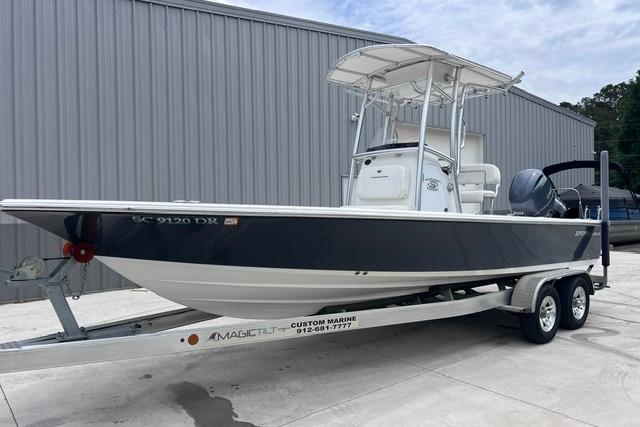 2021 Sportsman Tournament 234 SBX Bay Boat on trailer, parked outside a metal building.