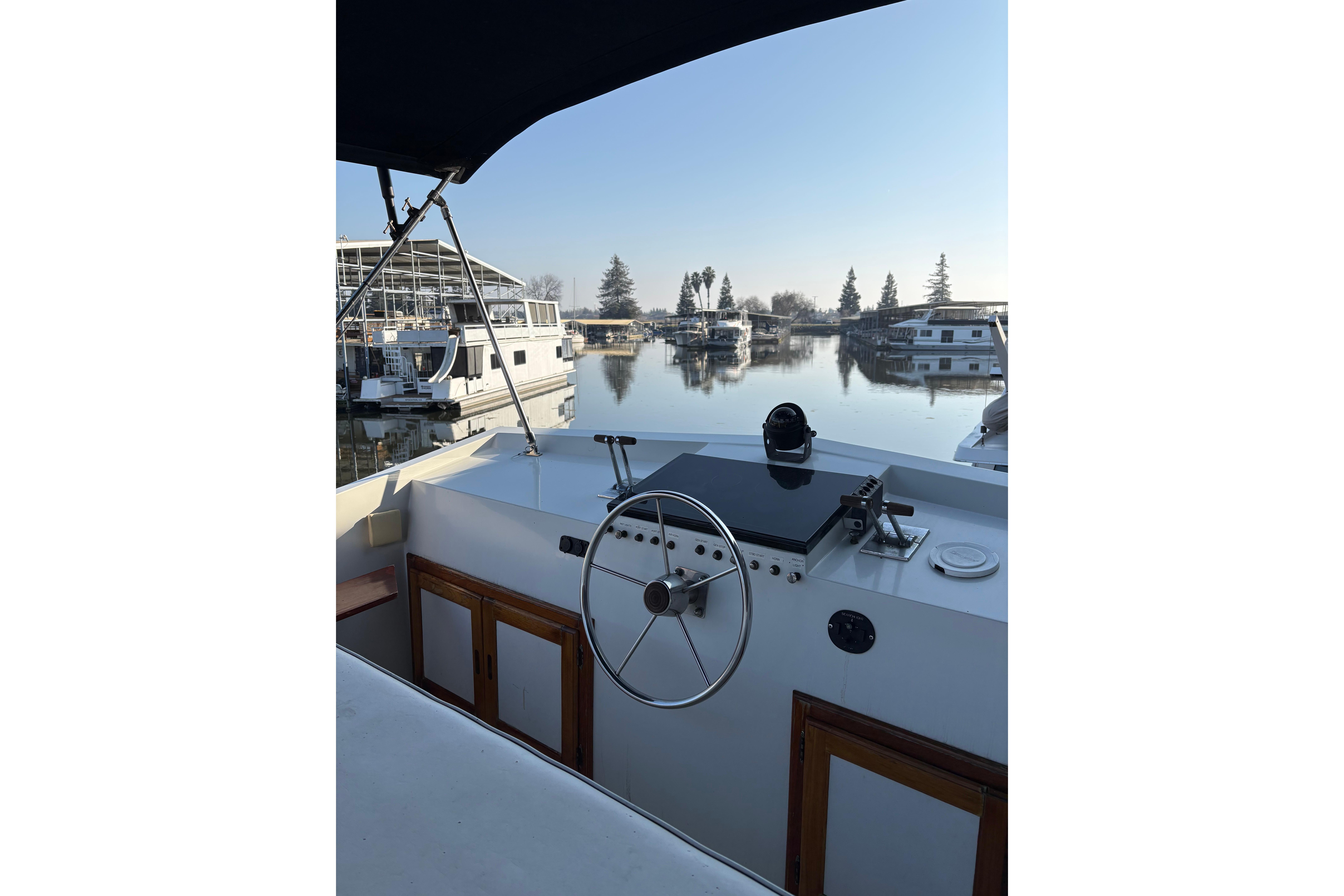 1978 Californian 42 LRC yacht helm with marina view, clear sky, and calm waters.