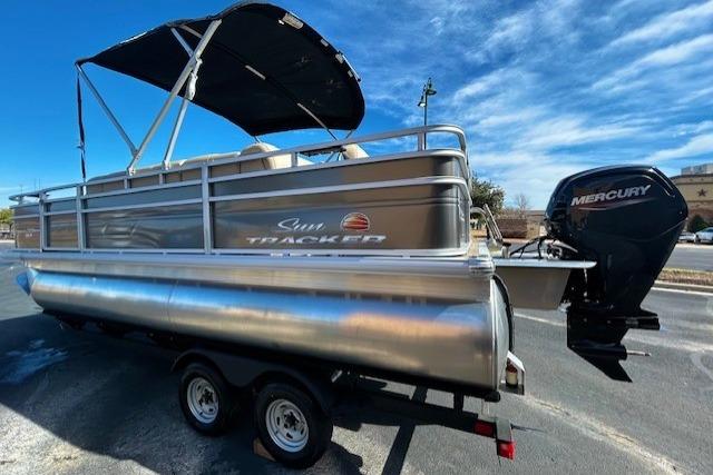 2025 Sun Tracker Fishin' Barge 20 DLX pontoon boat with Mercury engine on trailer.
