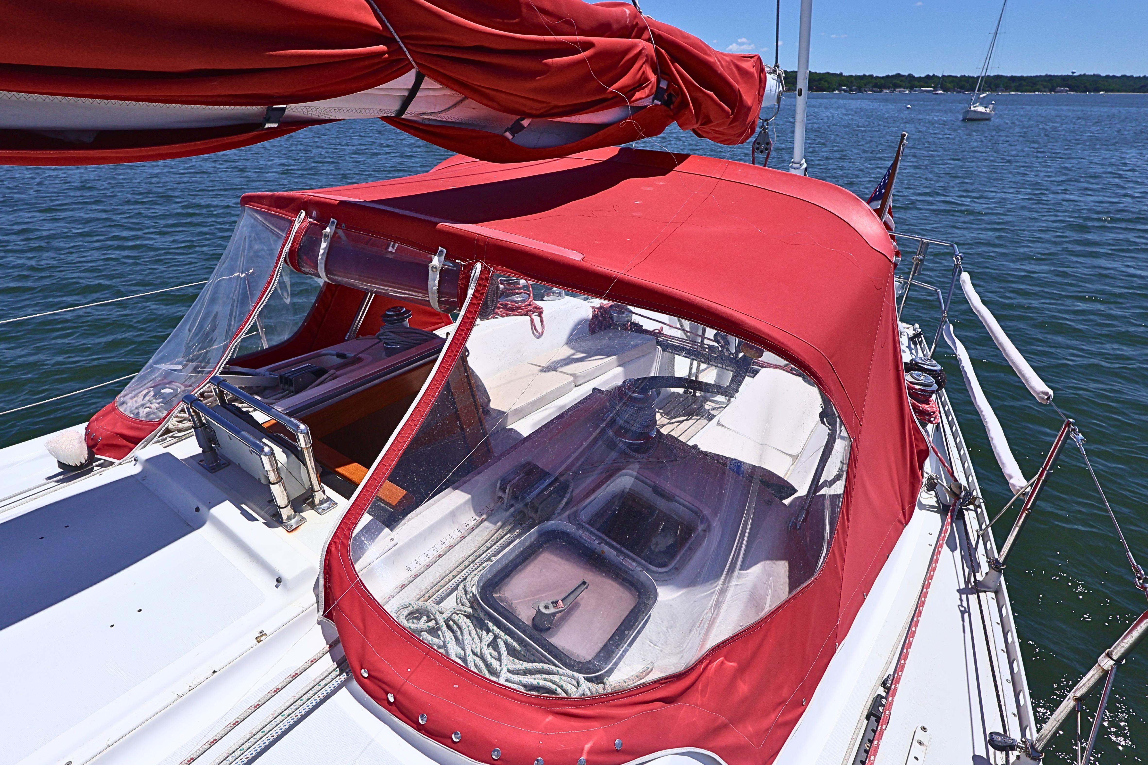 1989 J Boat J 40 sailboat with red canopy on calm water.
