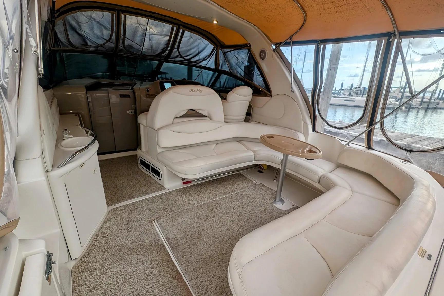 Luxurious interior of 2000 Sea Ray 380 Sundancer yacht with plush seating and panoramic windows.