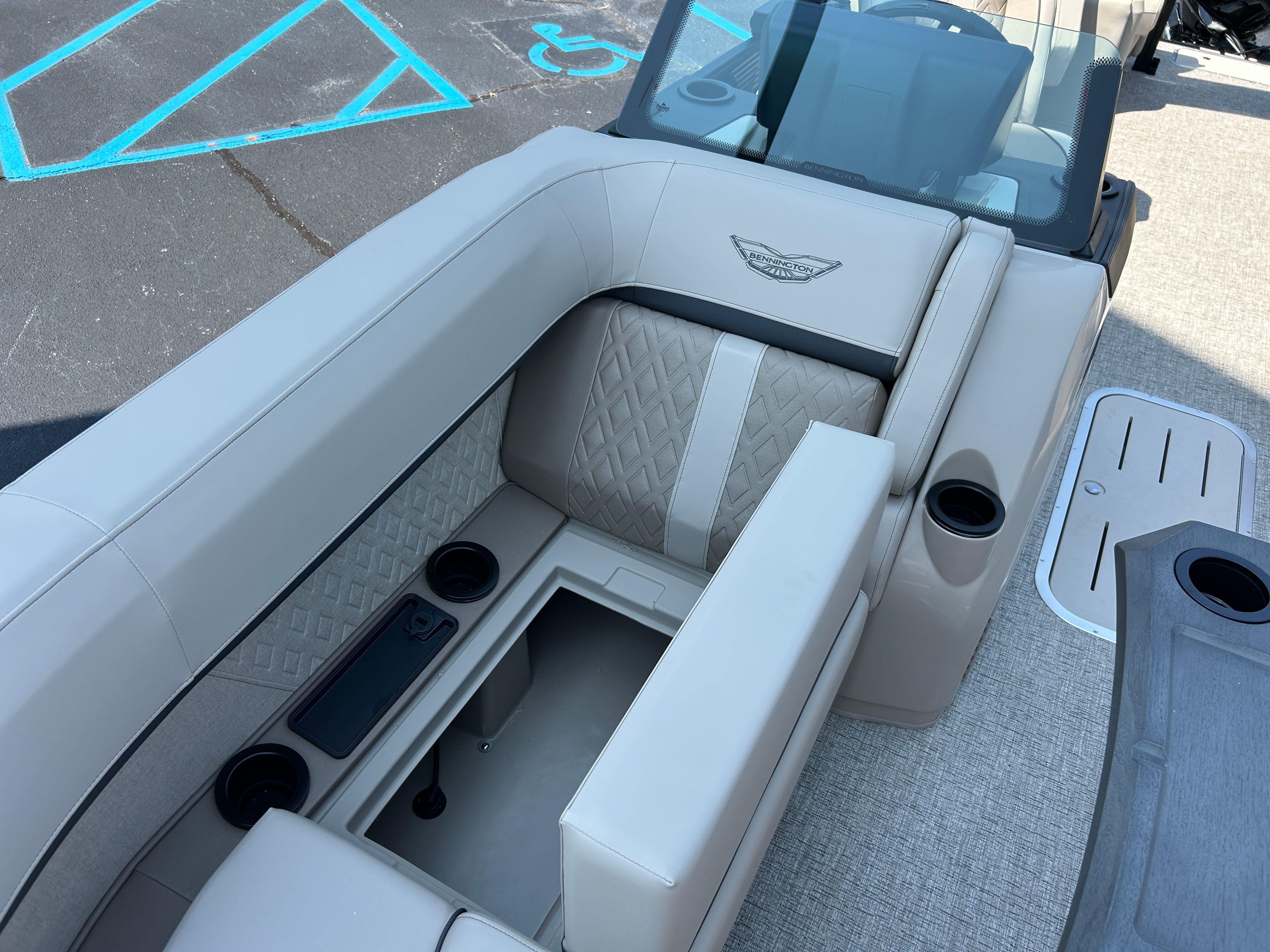 The image shows the interior of a Bennington 22 MFB boat with beige upholstery and cup holders.