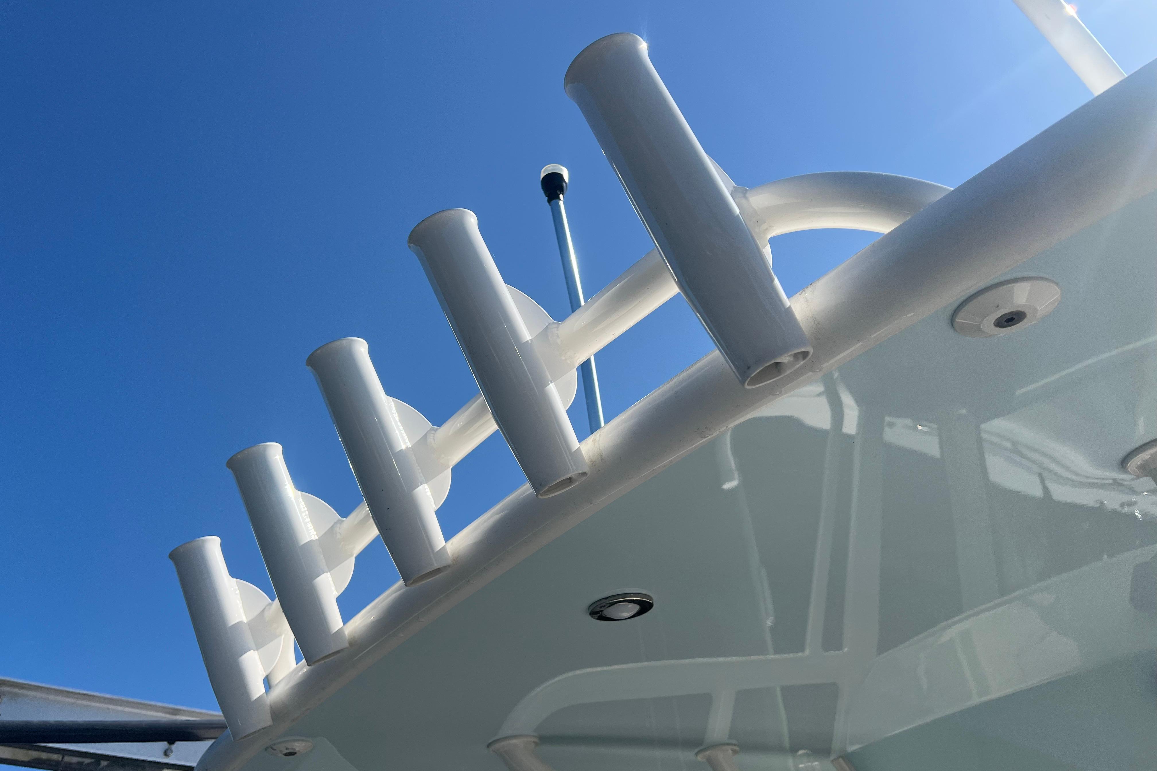 2022 World Cat 280 CC-X boat with rod holders against clear blue sky.