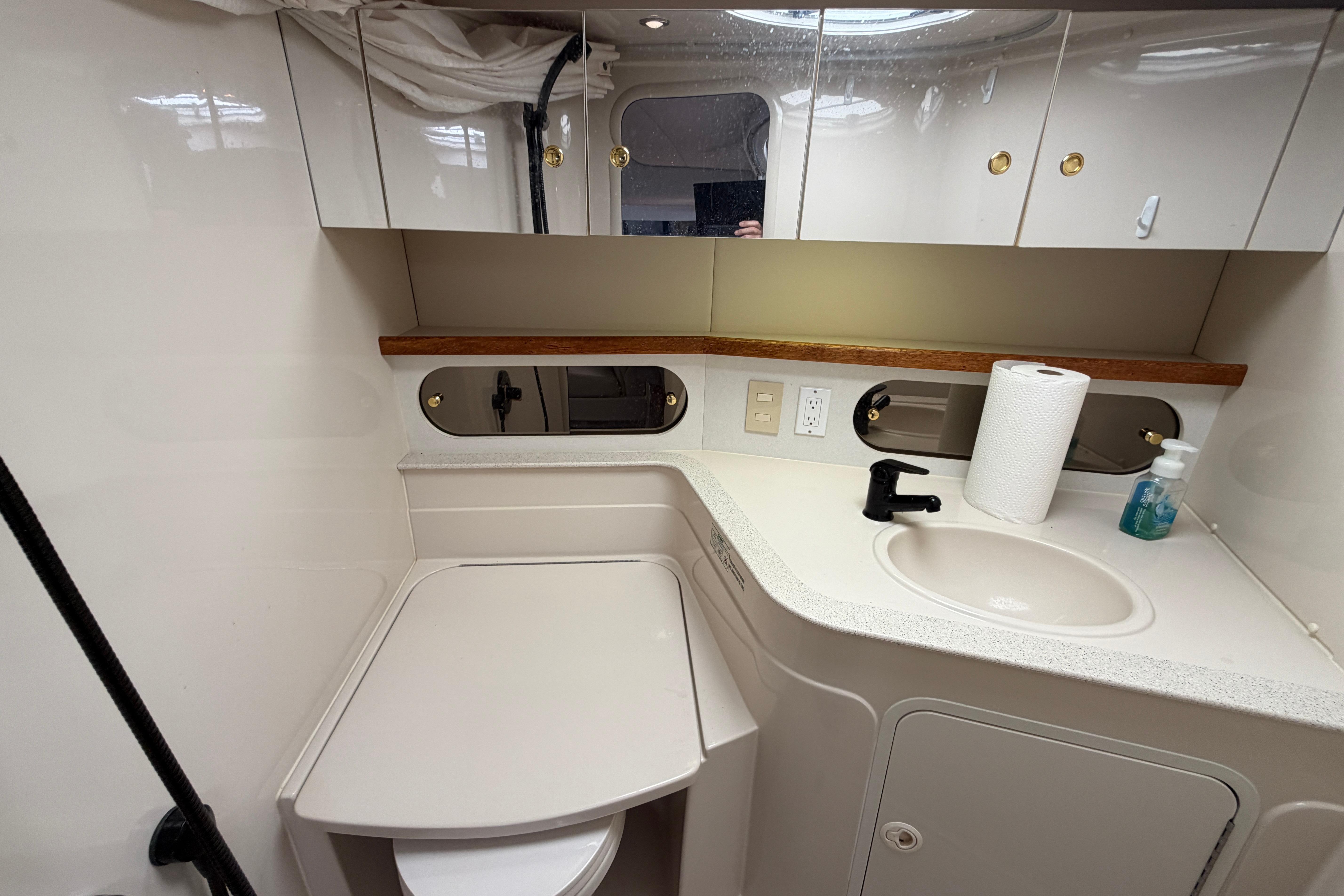 1997 Cruisers 3575 yacht bathroom with sink, mirror, and storage cabinets.